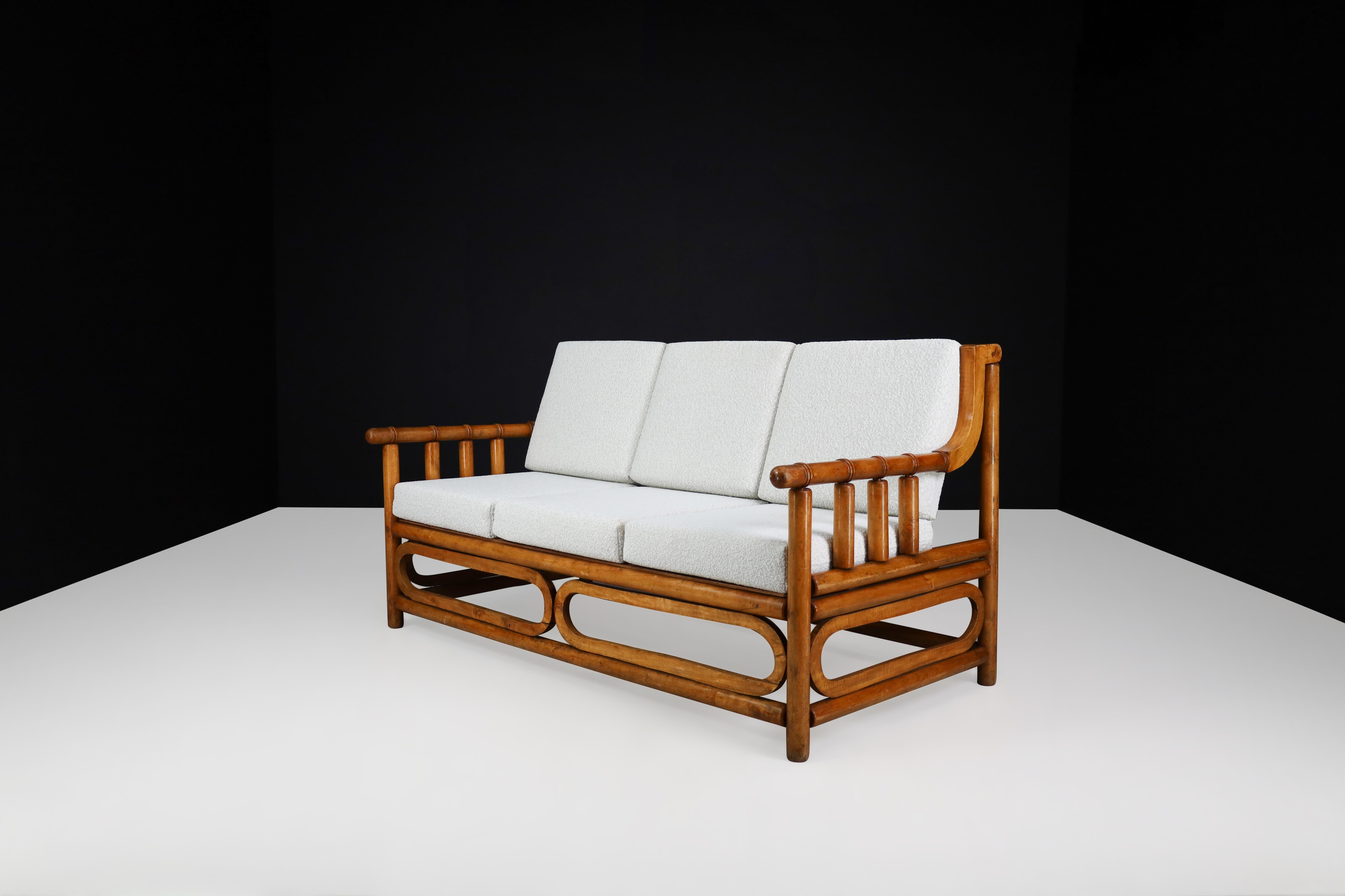 Sofa aus der Mitte des Jahrhunderts aus Bambusholz und Bouclé-Polsterung, Frankreich, 1950er Jahre.

Dieses exquisite Sofa aus Bambus und Holz stammt aus Frankreich und wurde in den 1950er Jahren mit Raffinesse hergestellt. Die kürzlich erfolgte