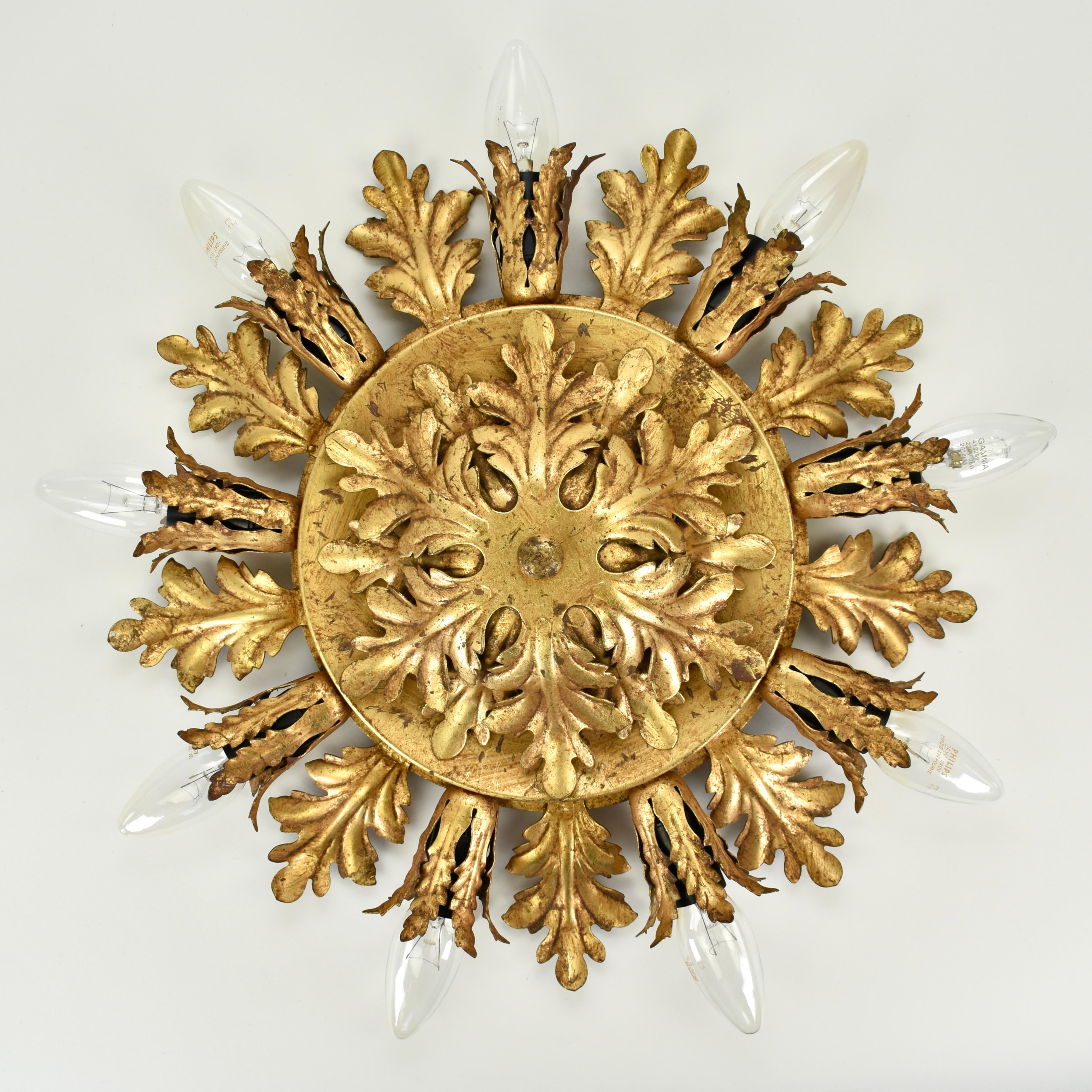 Impresionante lámpara de techo dorada de los años 70 fabricada por Banci Firenze. De hierro recubierto de pan de oro. Hay 9 puntos de luz que admiten cada uno un tamaño de accesorio e14.  

Diámetro (sin bombillas): 40 cm / 15,75