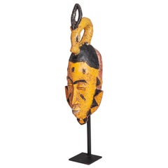 Maschera tribale Baoule di metà secolo in giallo-nero con decorazione a testa di antilope