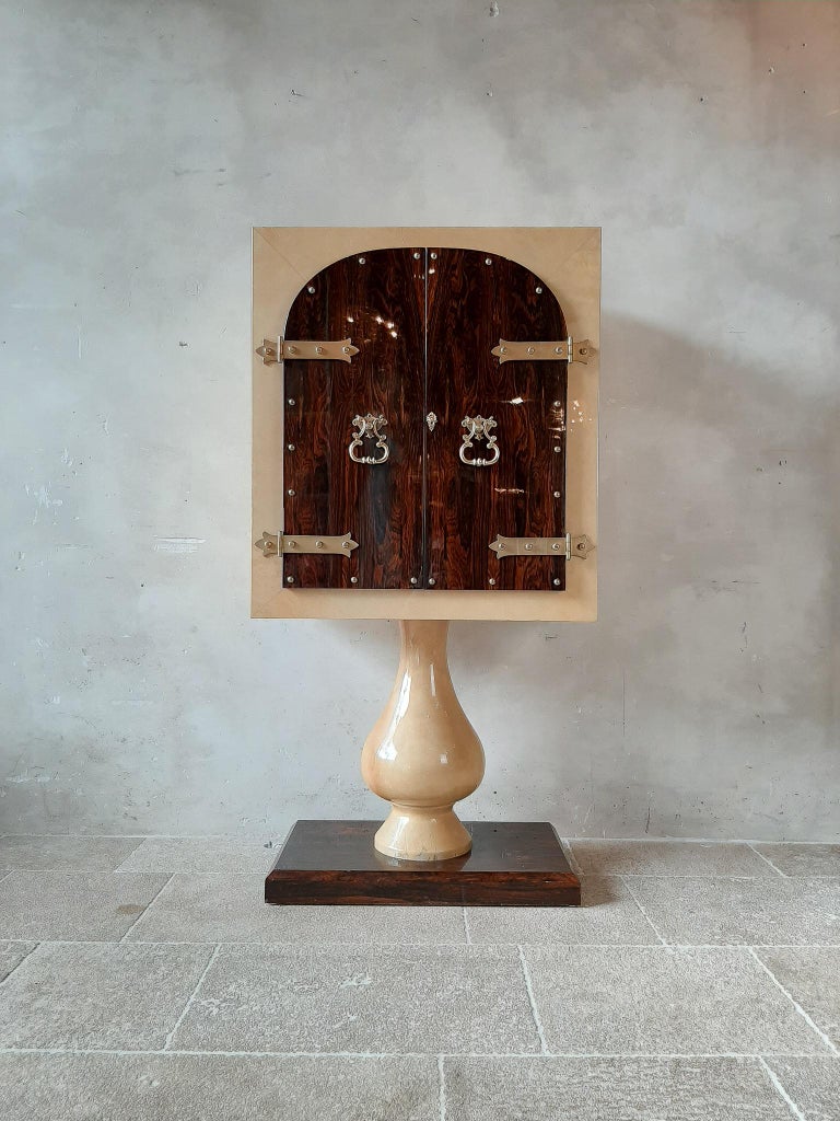 Midcentury, Italian standing bar cabinet by Aldo Tura (1909-1963). In lacquered wood, stained goatskin (parchment) and brass, 1950s Italy. This Hollywood Regency cabinet has been finished with a high gloss lacquer. Under this layer an off-white /
