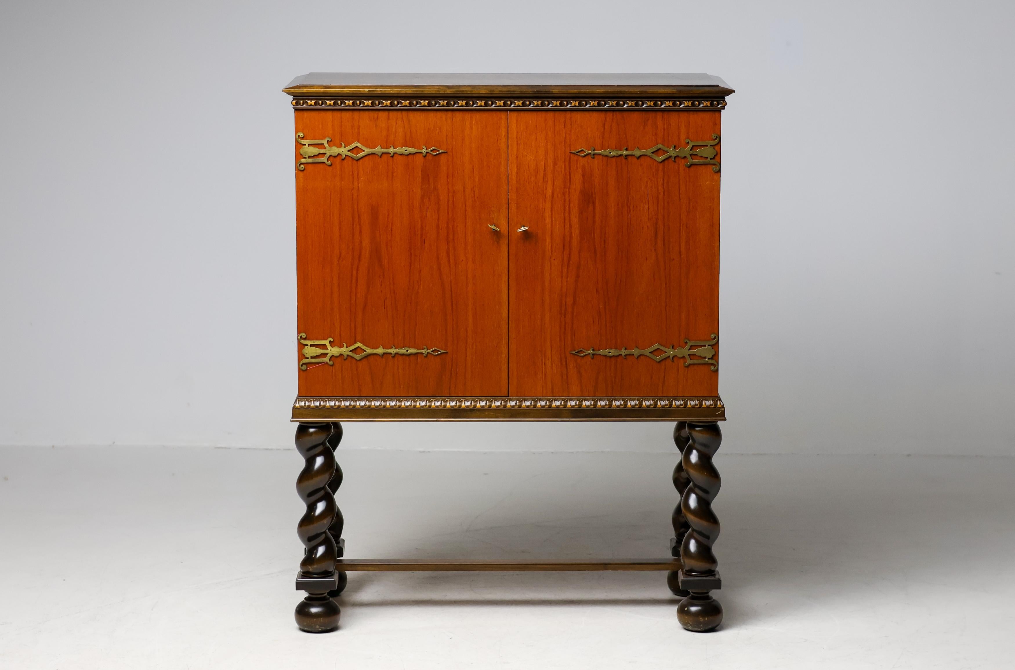 A striking example of Scandinavian mid-century design, this bar cabinet by Möbelproduktion AB from Sweden, circa 1950s, embodies elegance, functionality, and craftsmanship. Constructed from rich, warm teak, dyed ash and burr walnut, the cabinet