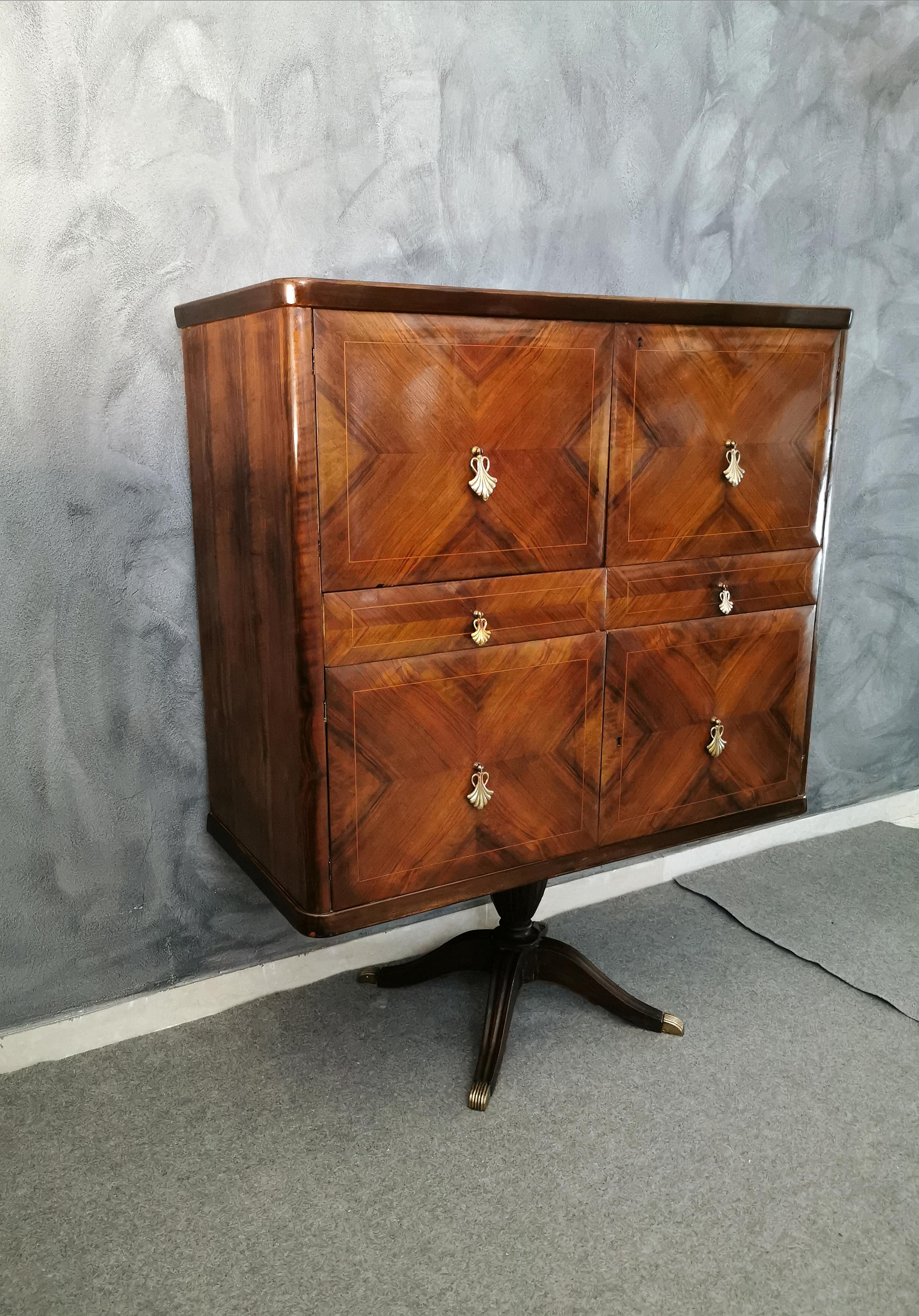 Exceptional bar cabinet by designer and architect Paolo Buffa, the furniture is rosewood veneer with a herringbone pattern and geometric designs. Supported by a central stem with 4 covered brass feet, on the front we have 2 drawers and 4 doors with
