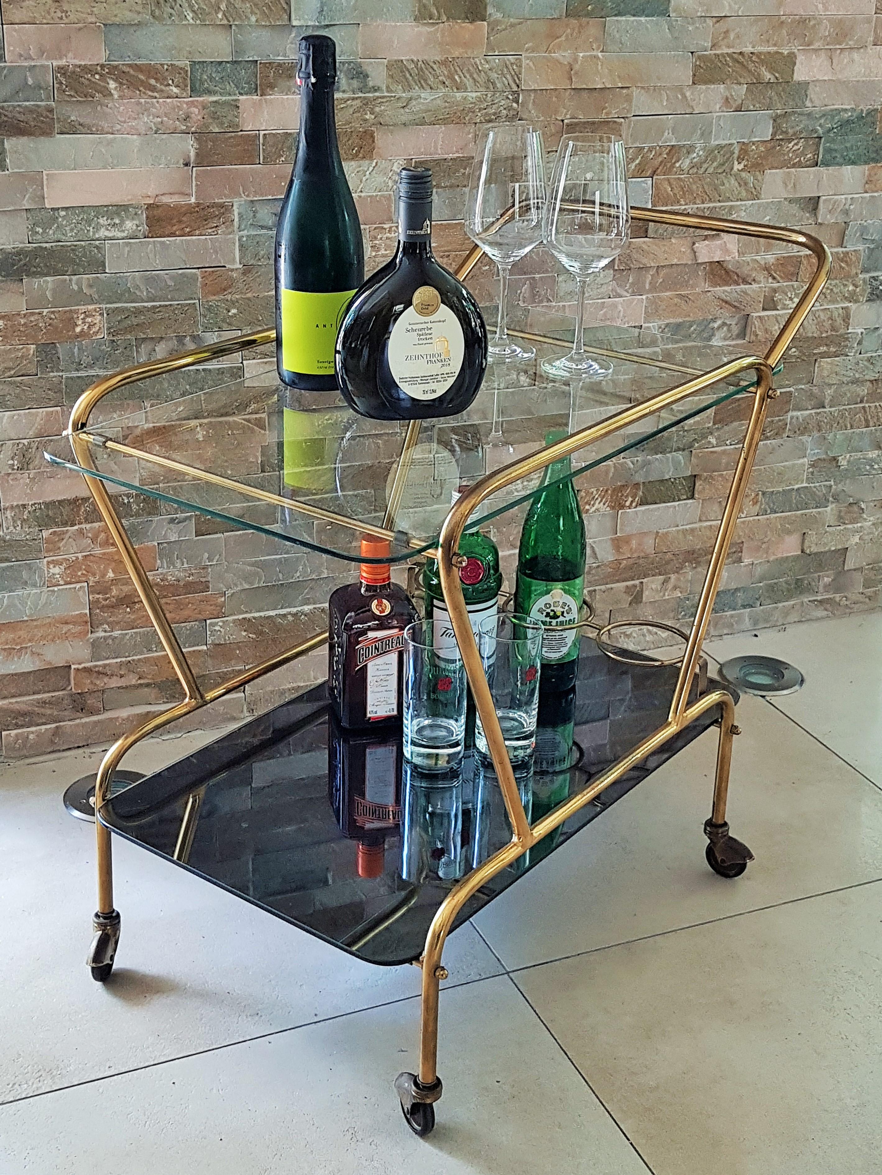 Midcentury bar cart brass and mirror by Cesare Lacca, Italy, 1950s.

Top shelve clear glass, bottom shelve black/grey mirror (very rare!).

Good vintage condition, castors work.