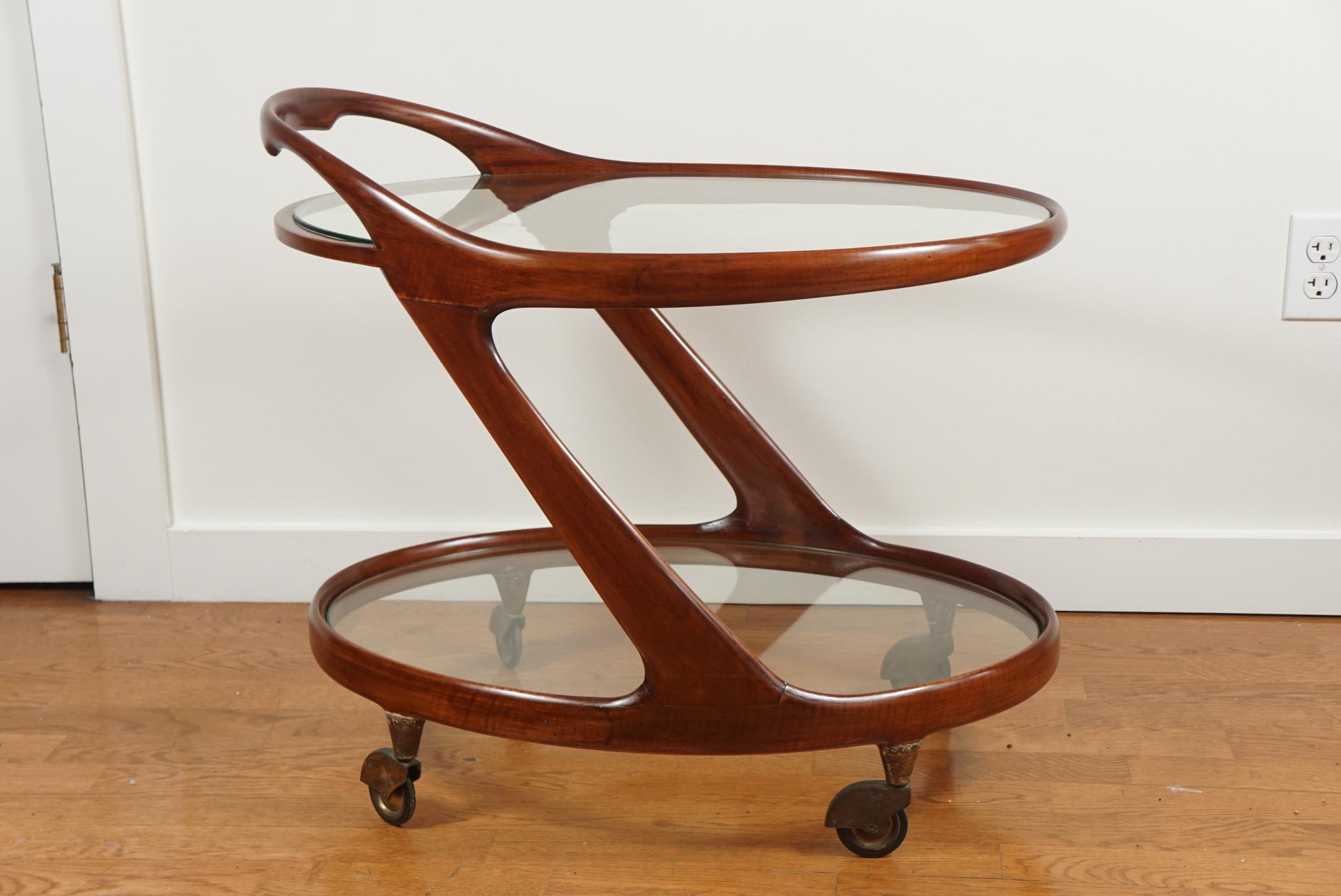 Italy, circa 1955
A graceful, oval shaped bar cart in mahogany and glass by designer, Paola Buffa.