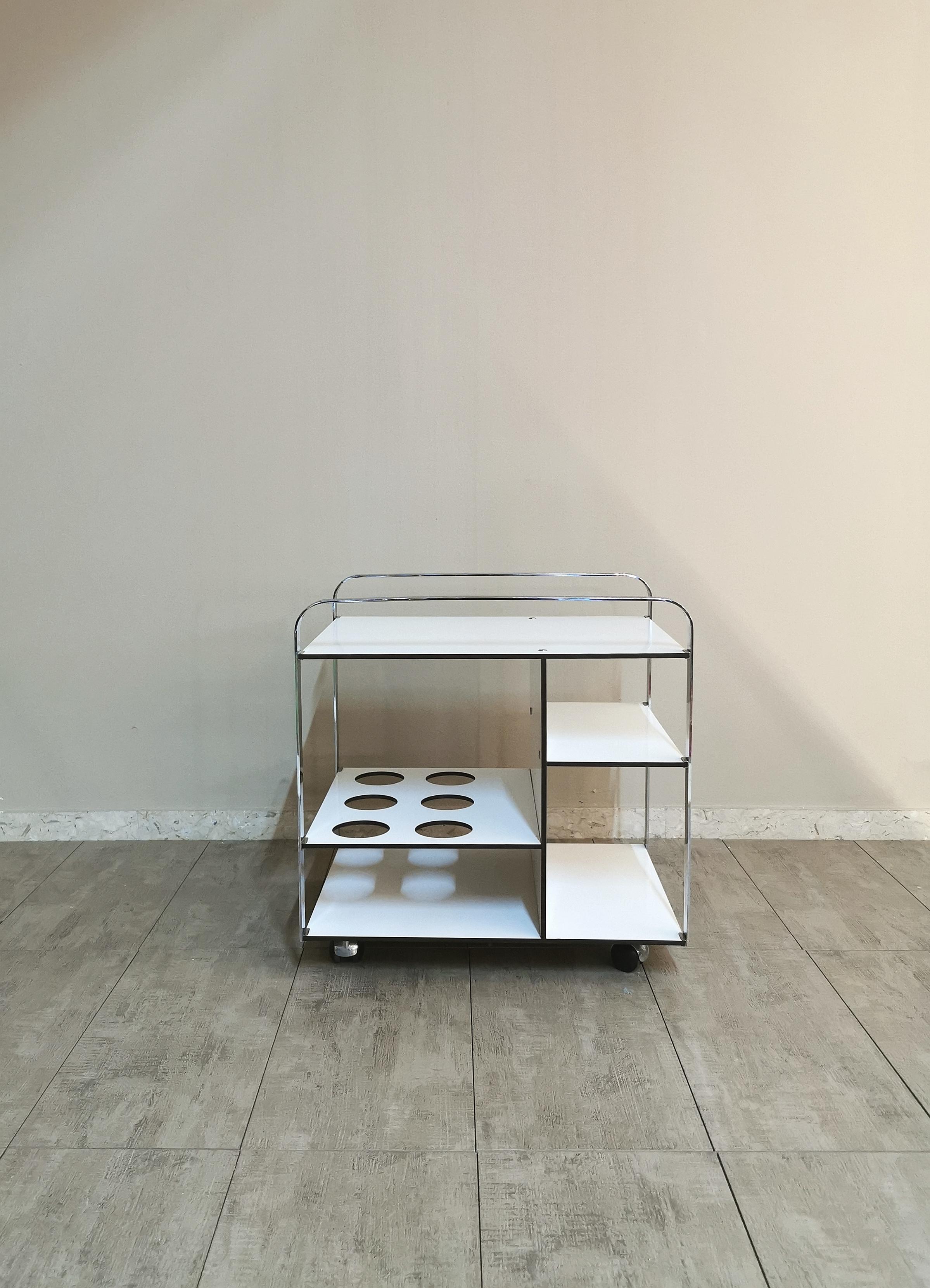 Bar cart by unknown designer with chromed metal structure with 4 shelves in white formica wood. In one of these shelves there are 6 lunchbox compartments. Made in Italy in the 70s.
