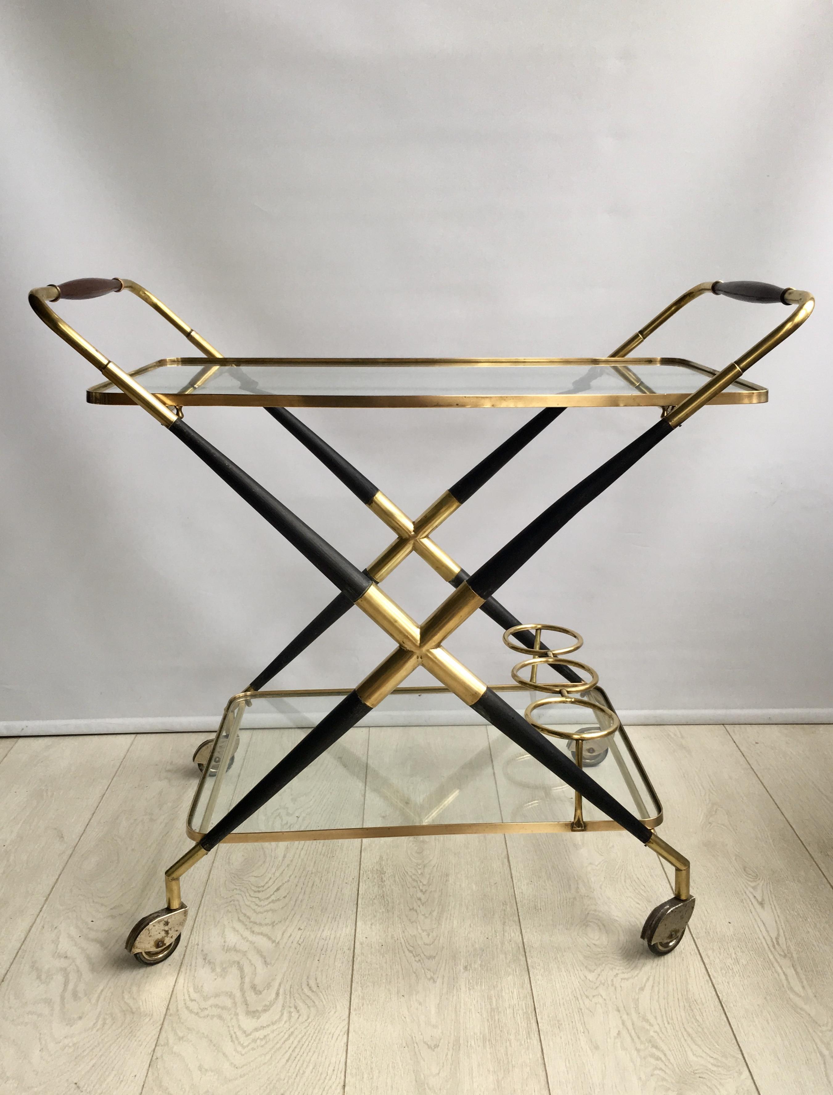 A fantastic midcentury bar cart by Cesare Lacca, Italy

In stained laquered beech and brass with a design typical for Lacca. 

Two tiers with clear glass and a holder for three bottles at the bottom.
 