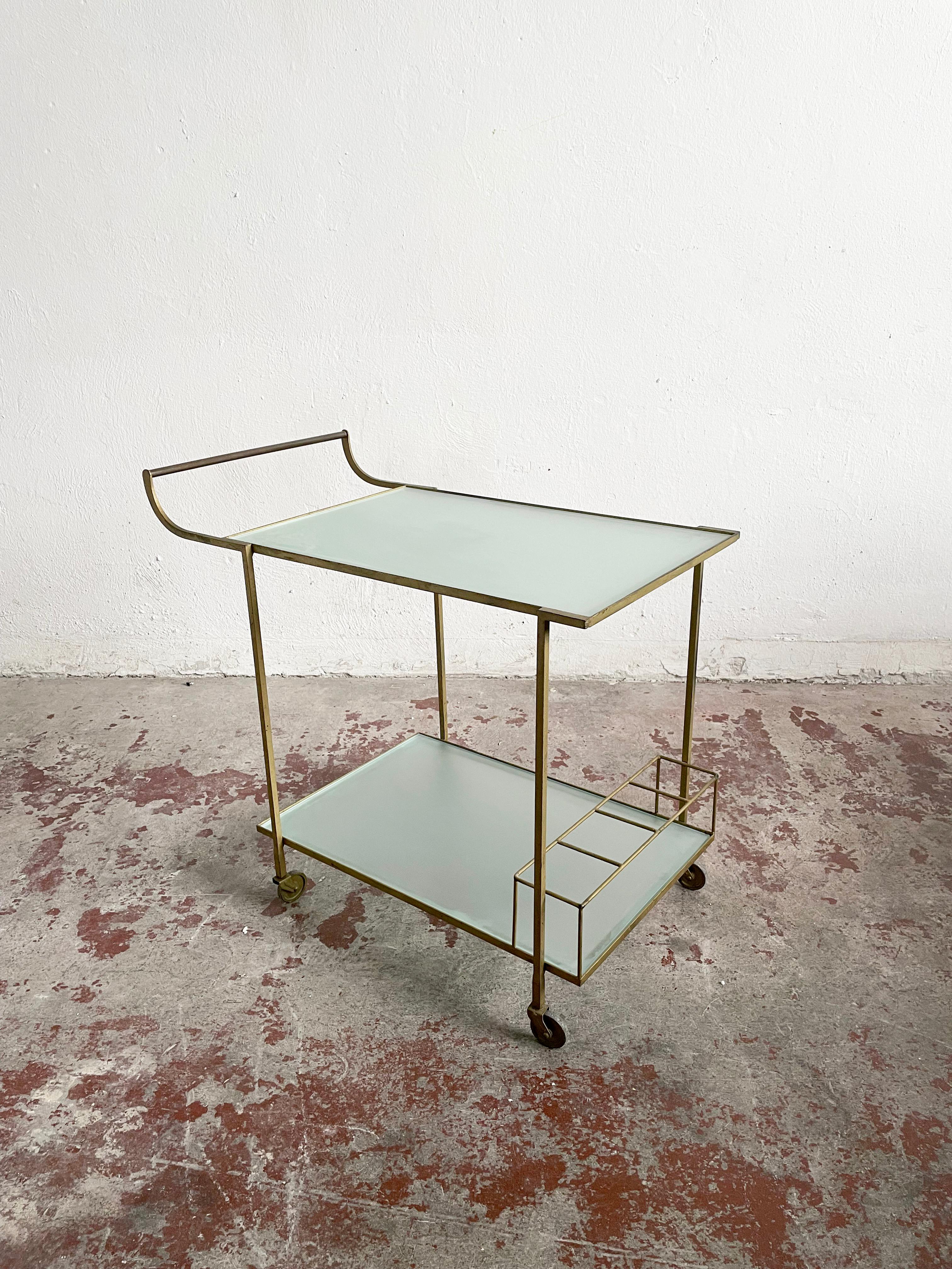 Vintage artisan bar cart in beautiful and stylish minimalist form

Bauhaus design

Year of production: circa the 1930s-1950s

Minimalist metal frame painted in gold colour, rough finish
Two shelves made of frosted glass


Dimensions: