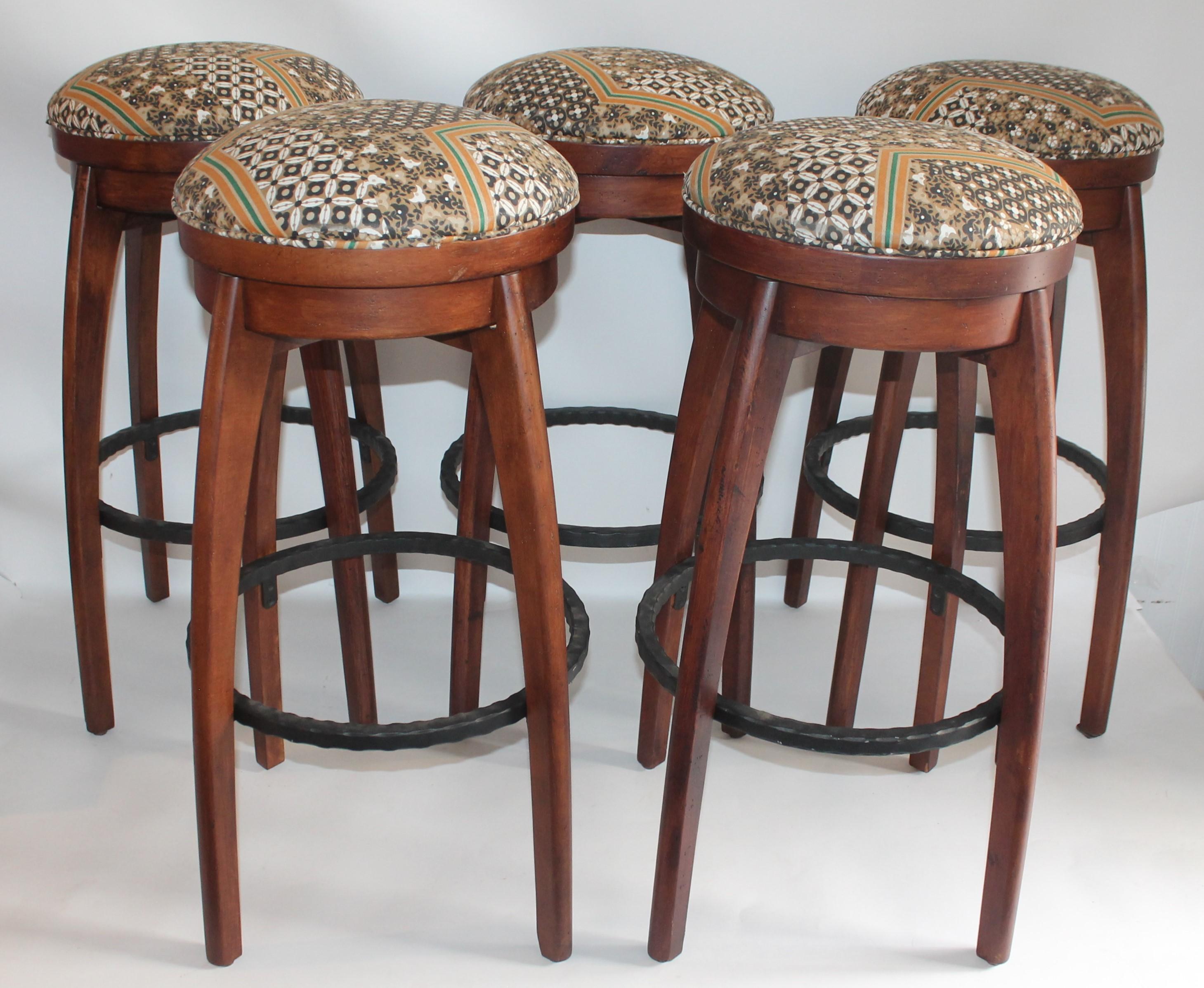These amazing rustic and very comfortable swivel bar stools are in fine condition. The tribal modern printed fabric on the seats are in good condition as well. These stools swivel and have a iron foot rest.