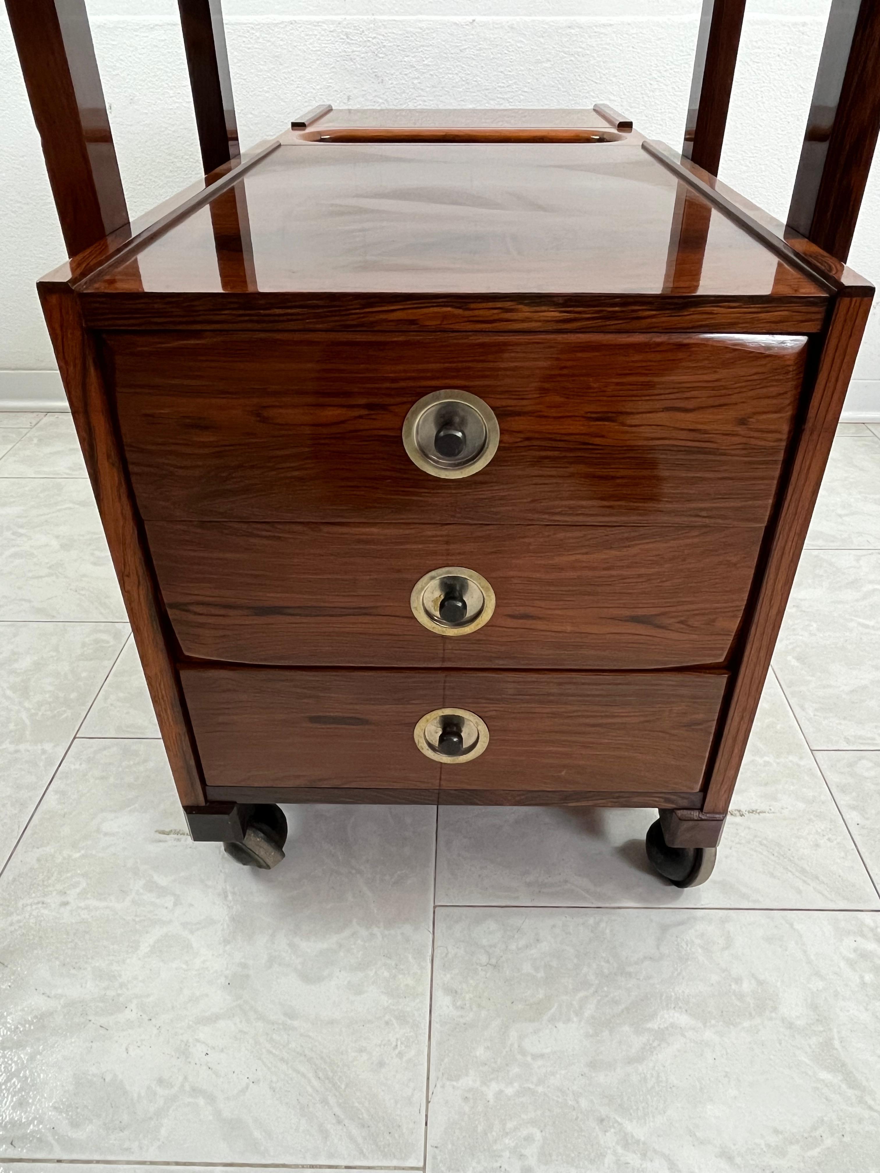 Mid-Century bar trolley cabinet, 1960s Italian design, attributed to Edmondo Palutari.
4 swivel wheels, intact and in good condition.
It has three drawers with recessed handles.
On the opposite side of the drawers it has two open compartments. It