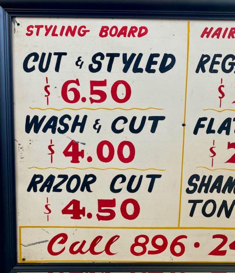 Early Vintage Barber Shop Sign, circa late 1950s to early 1960s, a hand-painted sheet metal sign with old prices for old hair cuts. The sign remains in very good condition with only a few scrapes to the paint, and having screw holes drilled in the