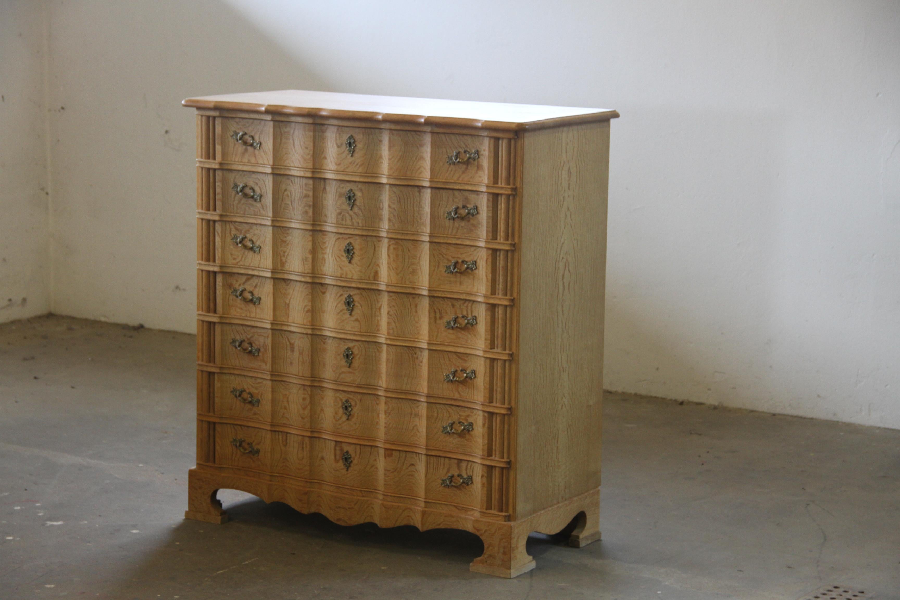 This big vintage Danish oak cabinet is in perfect working condition. It has a beautiful patina and strong lines, with a clean and sculptural design.

The legs have an outgoing curve reminiscent of French design, while the wood carvings on the front
