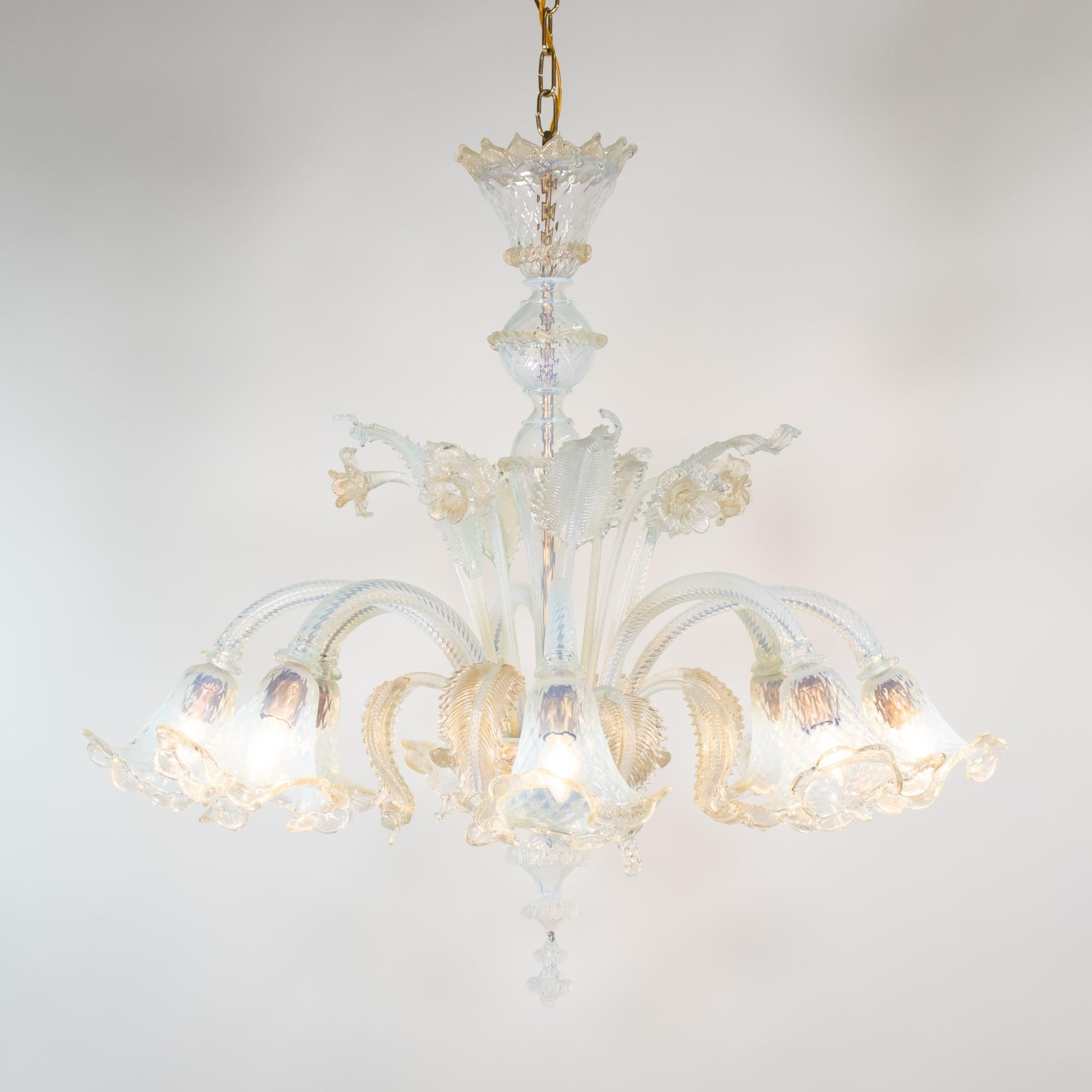 This vintage baroque style handcrafted gold-infused opaline Murano chandelier has eight flexing arms with trilobed cups. The milky opaline glass veers towards a light blue color with subtle changes in the light. Daffodils and leaves embellish this