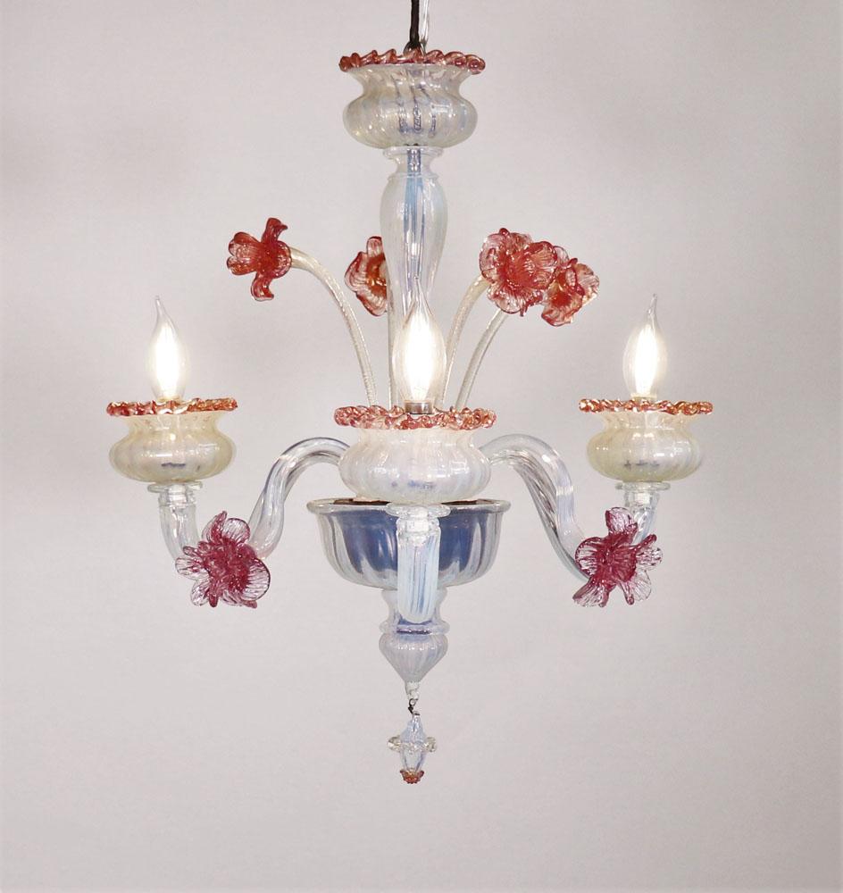 Diese florale Opaline im Barockstil mit golddurchwirktem Murano-Glas hat drei schöne Schneckenarme, die tulpenförmige Bobeches mit rotem Rigaree-Besatz halten.  Der Rigaree-Besatz wird durch Kräuseln der angebrachten Bänder hergestellt. 

Der Korpus