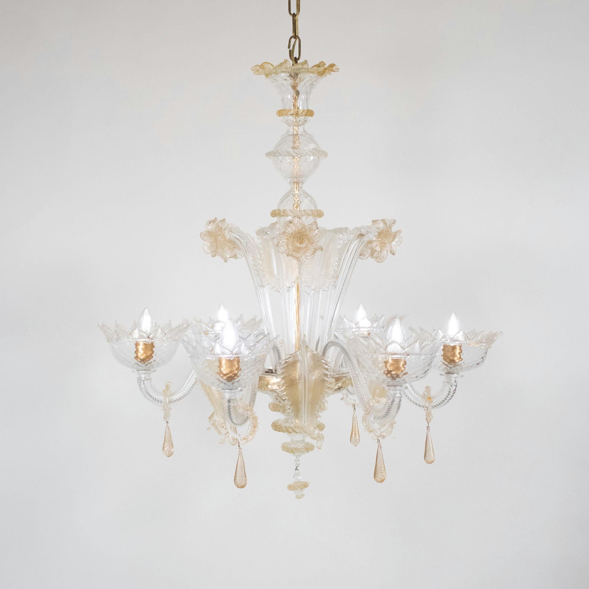 Questo lampadario in Cristallo di Murano in stile barocco di metà secolo è caratterizzato da sei bracci a voluta con coppe ornate di petali, da cui pendono baubles ad anello con gocce di vetro. Il centro è decorato con una serie di narcisi e foglie.