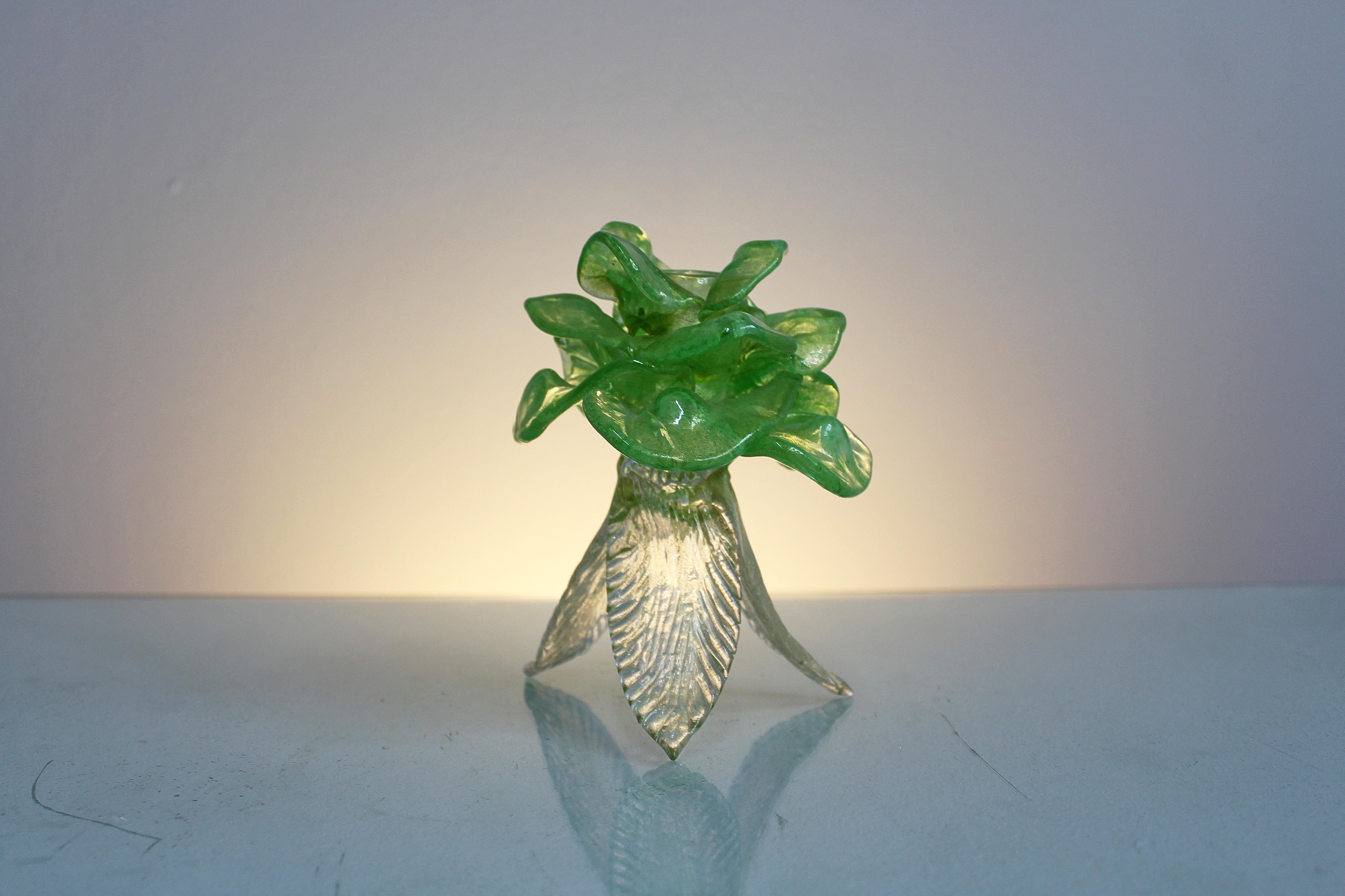 Sehr feiner Murano-Glas-Kerzenhalter mit grünen Blättern oben und transparent unten, alle mit Einschlüssen von Blattgold. Venezianische Manufaktur, die Barovier in den 1950er Jahren zugeschrieben wird.
Alters- und gebrauchsbedingte