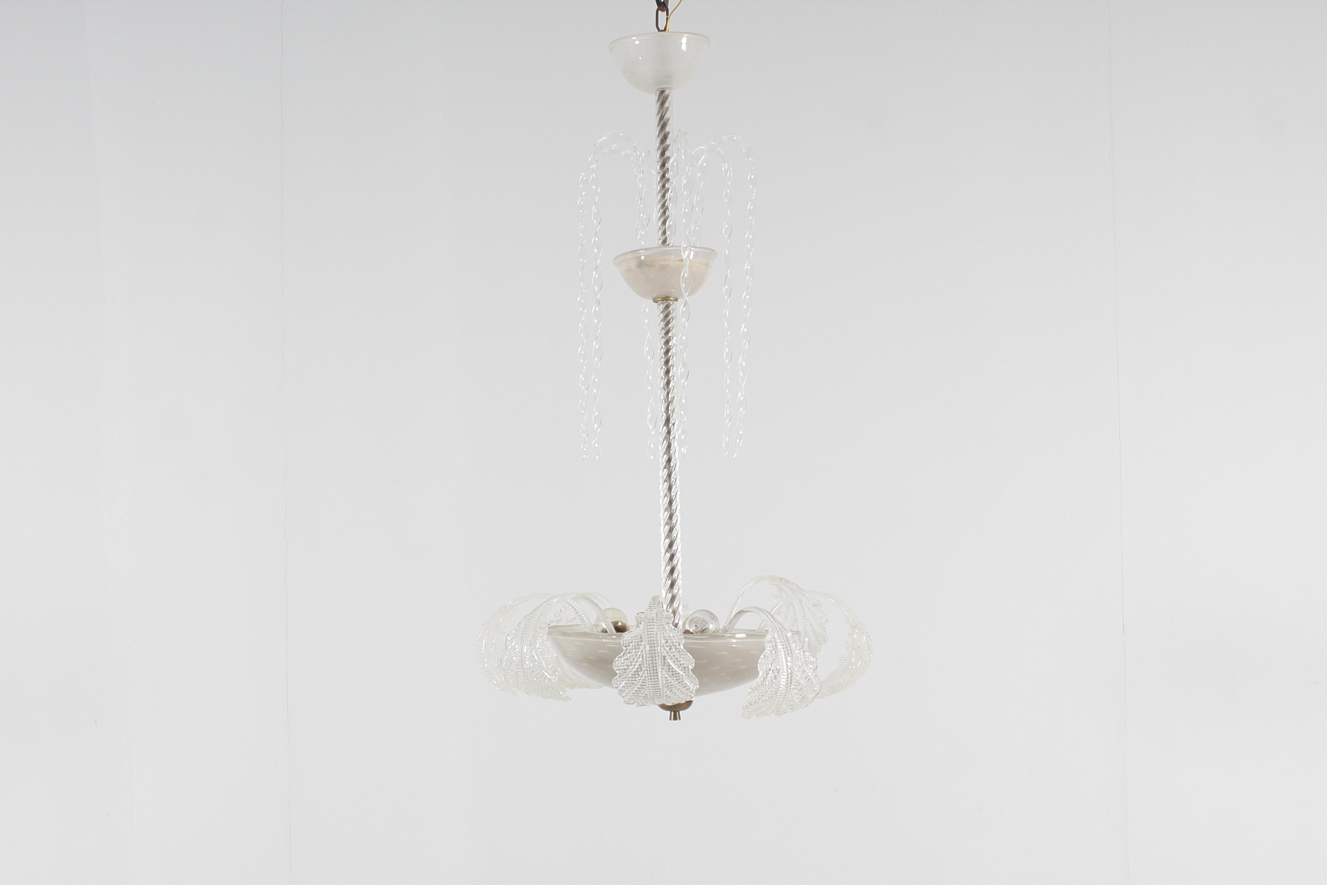 Enchanting three-light chandelier, in blown Murano glass. The supporting structure is made of burnished metal covered by the twisted glass rod and the large lower cup with submerged bubble decoration, from which ten netted acanthus leaves protrude.