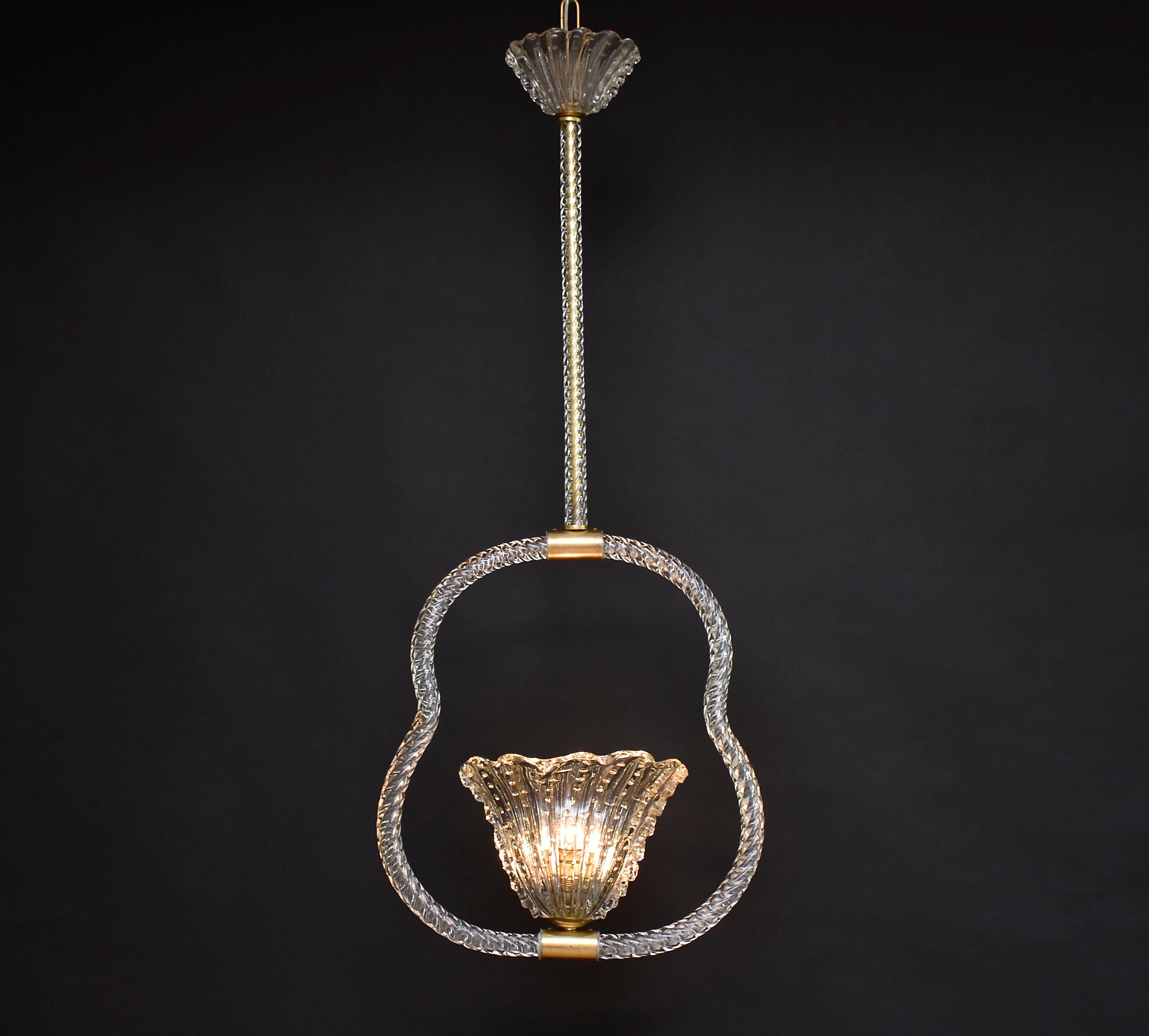 Beautiful Murano glass chandelier designed by the legendary company Barovier & Toso- master glassmaker!
The chandelier is made in transparent twisted Venetian crystal with brass elements and in the centre a blown glass vase with one light.
A unique