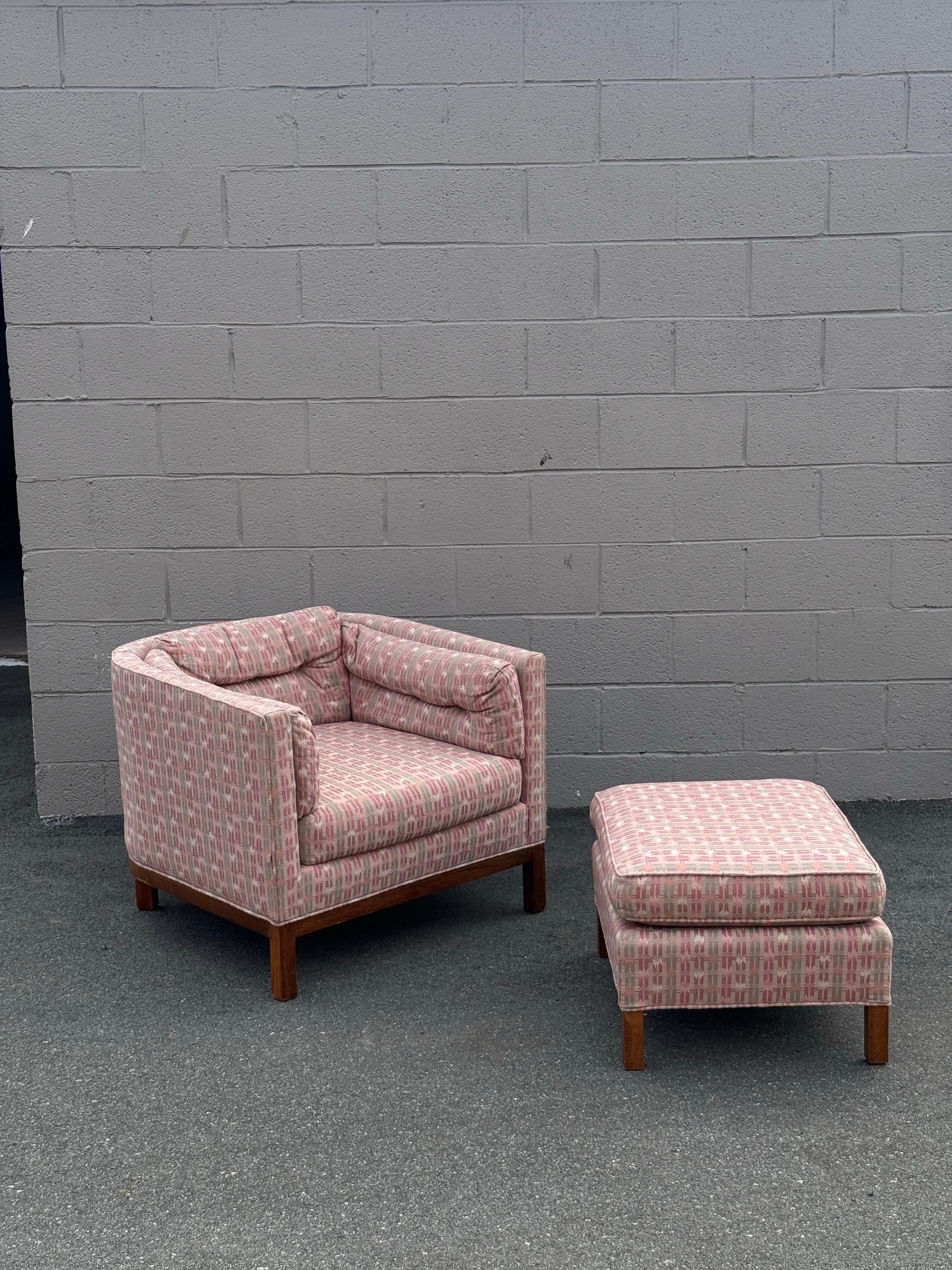 Sillón y otomana con respaldo de barril de mediados de siglo atribuidos a Dunbar. Esta silla tiene un diseño clásico de barril con reposabrazos que se unen a los respaldos. El respaldo es curvo, lo que añade carácter al perfil frontal cuadrado.