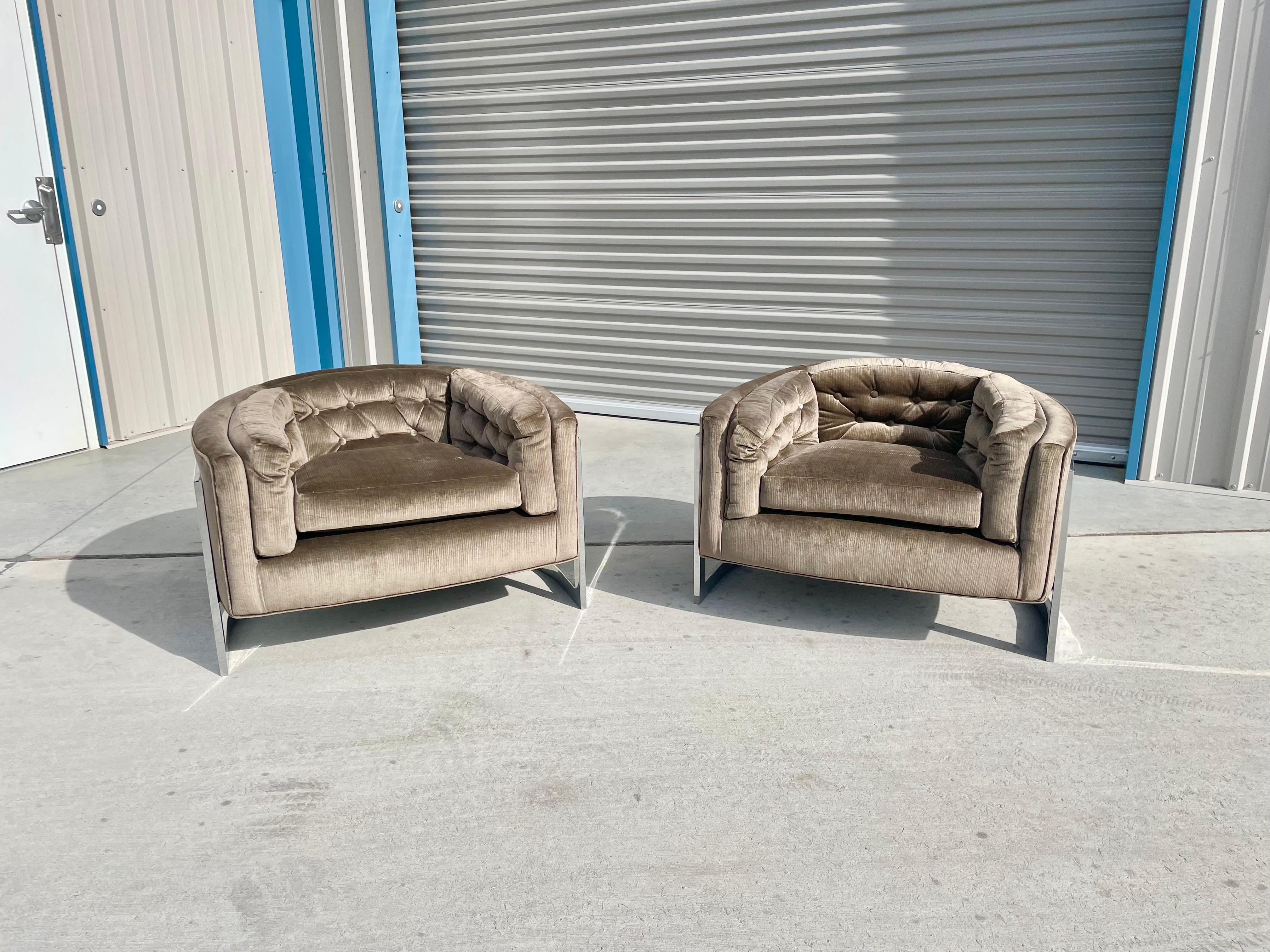 Midcentury Barrel lounge chairs designed by Jules Heumann for Metropolitan in the United States circa 1970s. This stunning pair of lounge chairs feature a barrel shape design on top of a chrome base wrapped around the seat, giving you the illusion