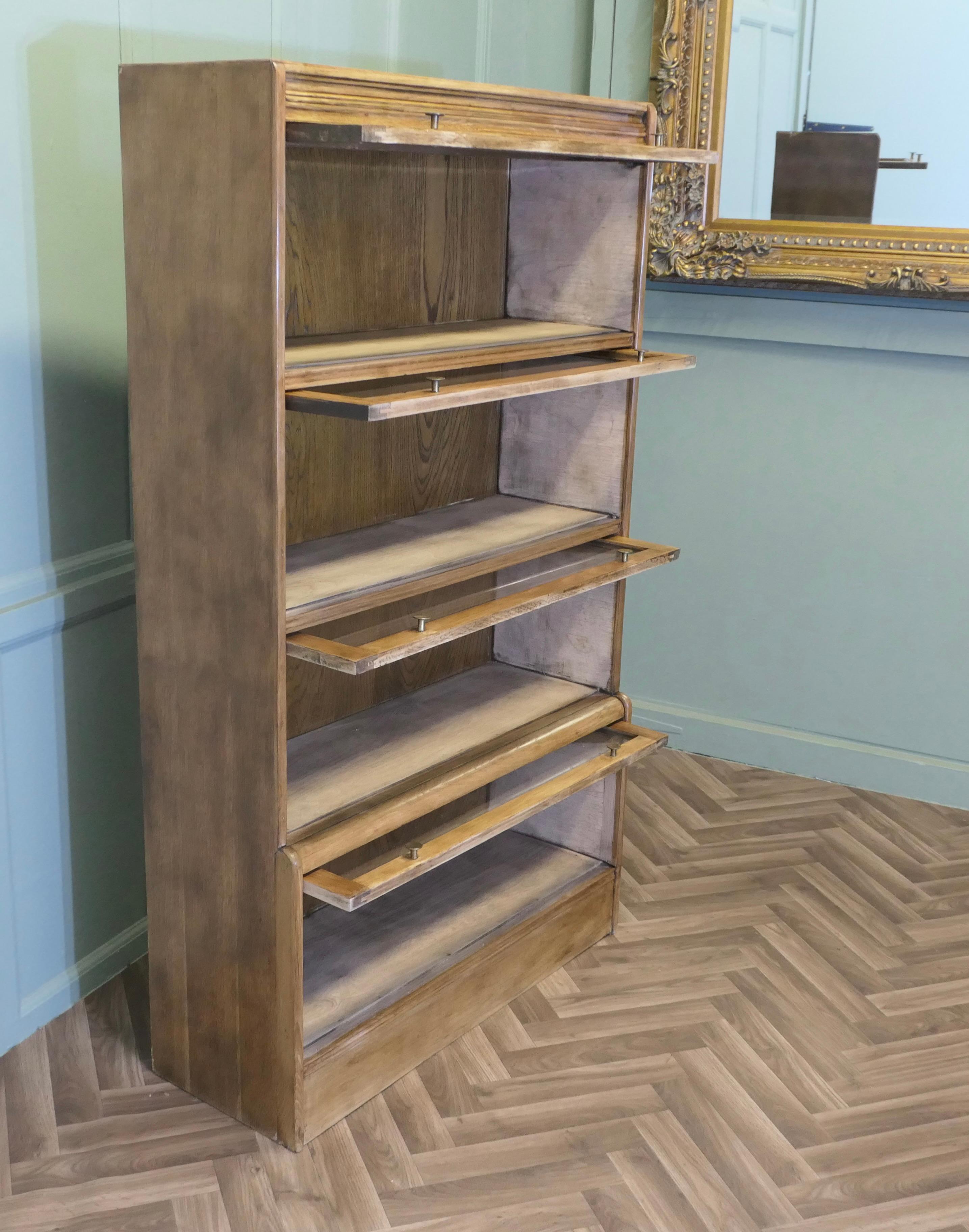 Librería o archivador para abogados de mediados de siglo

Se trata de una estantería o archivador de roble dorado de buena calidad, todos los estantes tienen una puerta basculante acristalada y pomos de latón
La estantería está en buen estado y mide