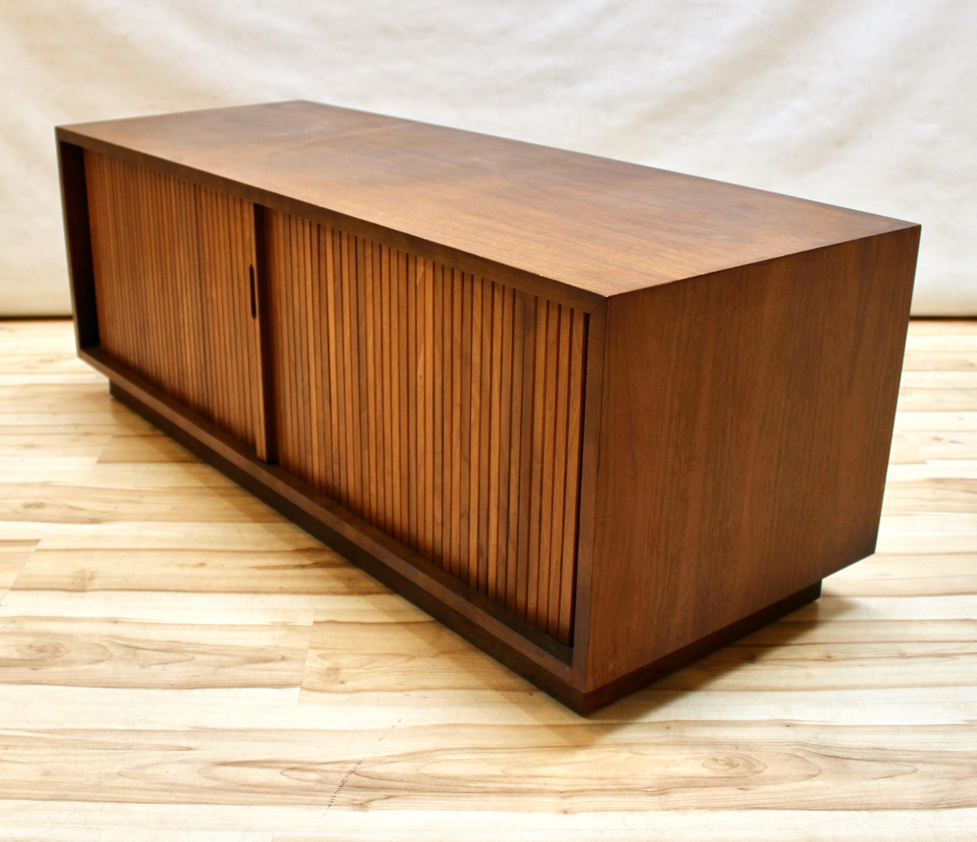 Mid-Century Modern Barzilay walnut record cabinet with tambour doors. The doors have sculpted pulls, and there are interior dividers for record storage. In excellent condition.

Measures: Width: 48 in / Depth: 18 in / Height: 17.75 in.