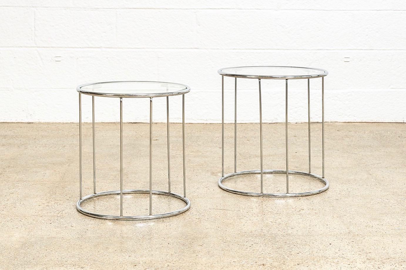 This two-piece set of vintage Mid-Century Modern Milo Baughman style round nesting tables is circa 1970. The elegant, Minimalist design features a chrome-plated round spoke frame with removable glass tops. One slightly larger table fits neatly over