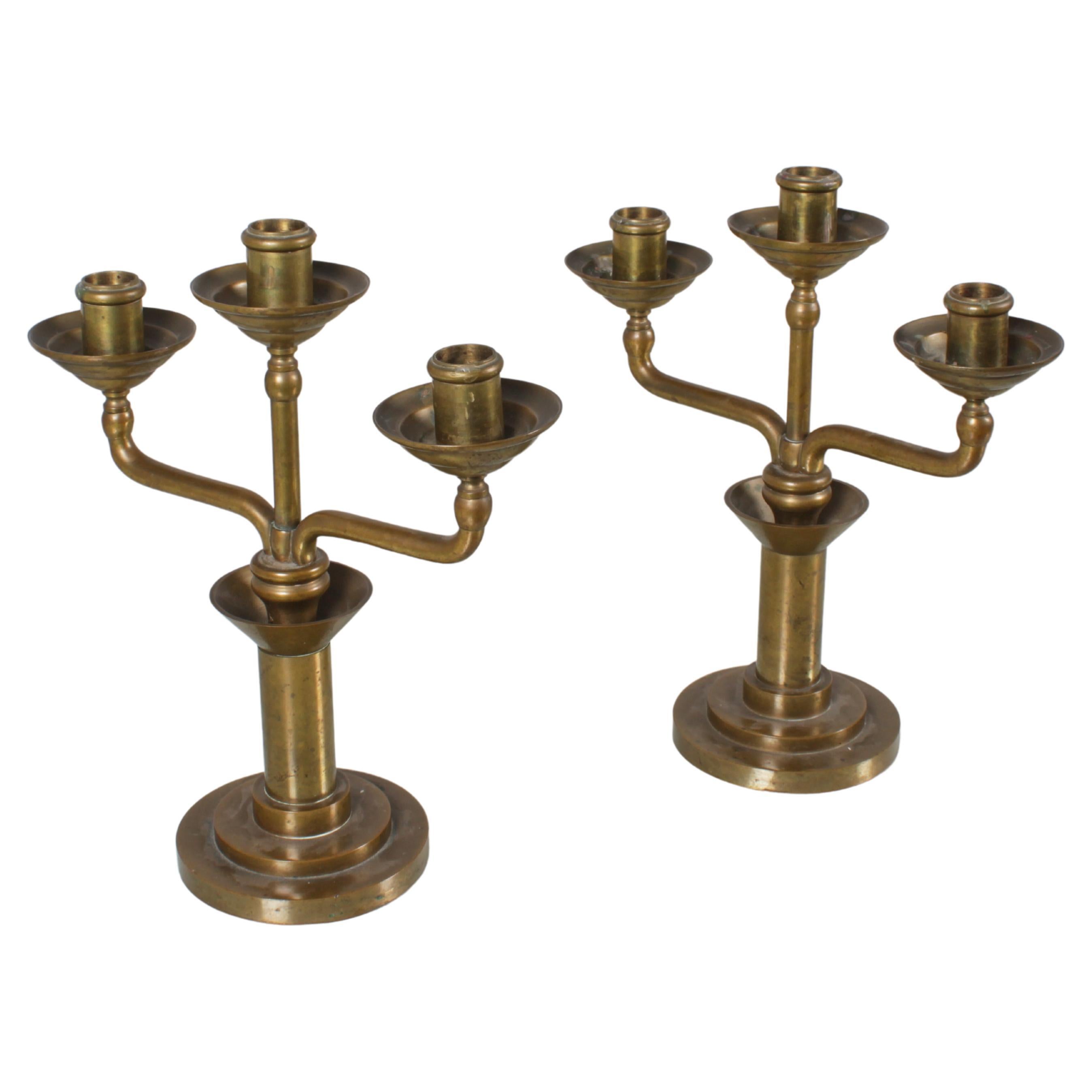 Refined Bauhouse pair of turned solid brass candelabra with two curved lateral arms and a central one. Italian production from the 30s.
Wear consistent with age and use.
 