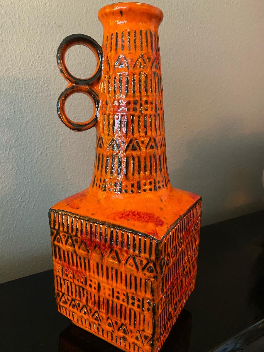 Una baia con motivi runici stampati, disegnata da Bodo Mans, questo motivo era molto popolare negli anni '60. Questo vaso alto è in ottime condizioni e presenta uno smalto arancione.