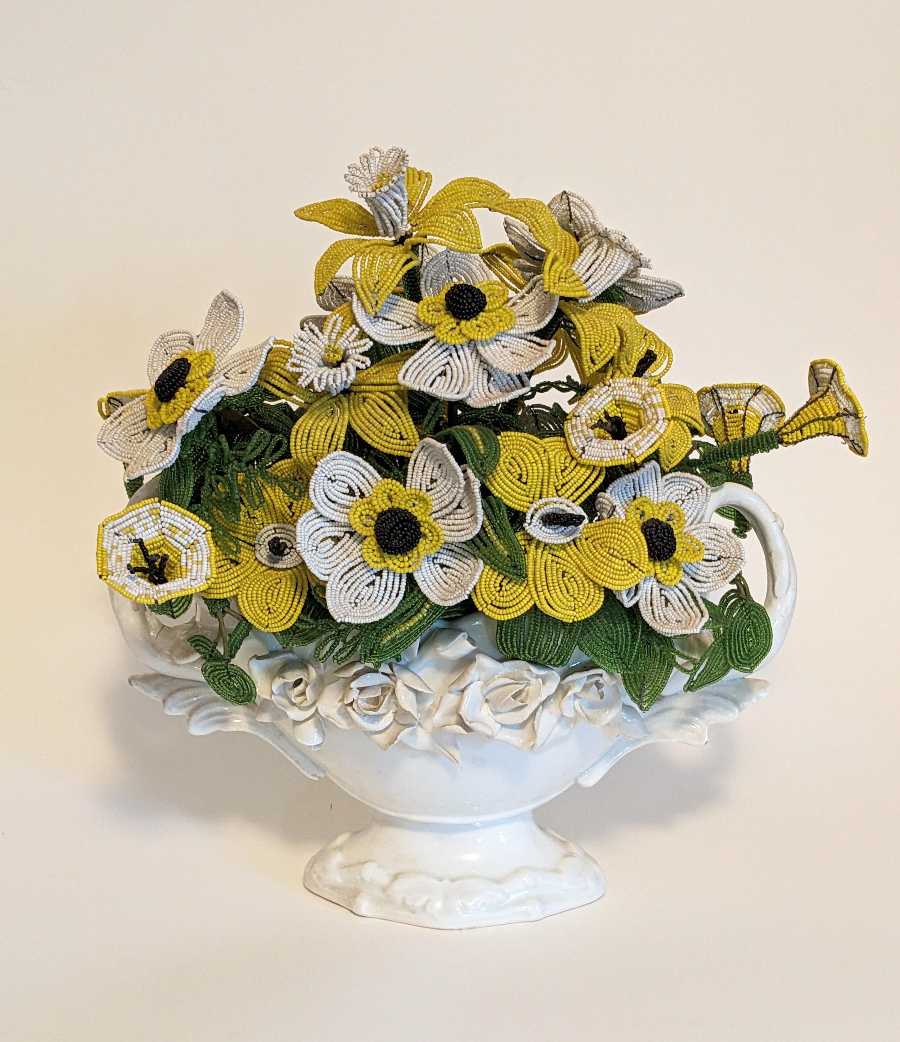 Beaded Flower Arrangement from the 1960's. The rage for beaded flowers started in the 1960's and ornate labor intensive, professionally made pots were de rigeur in many households throughout the country. 
Pot of hand made Daffodils, Poppies and