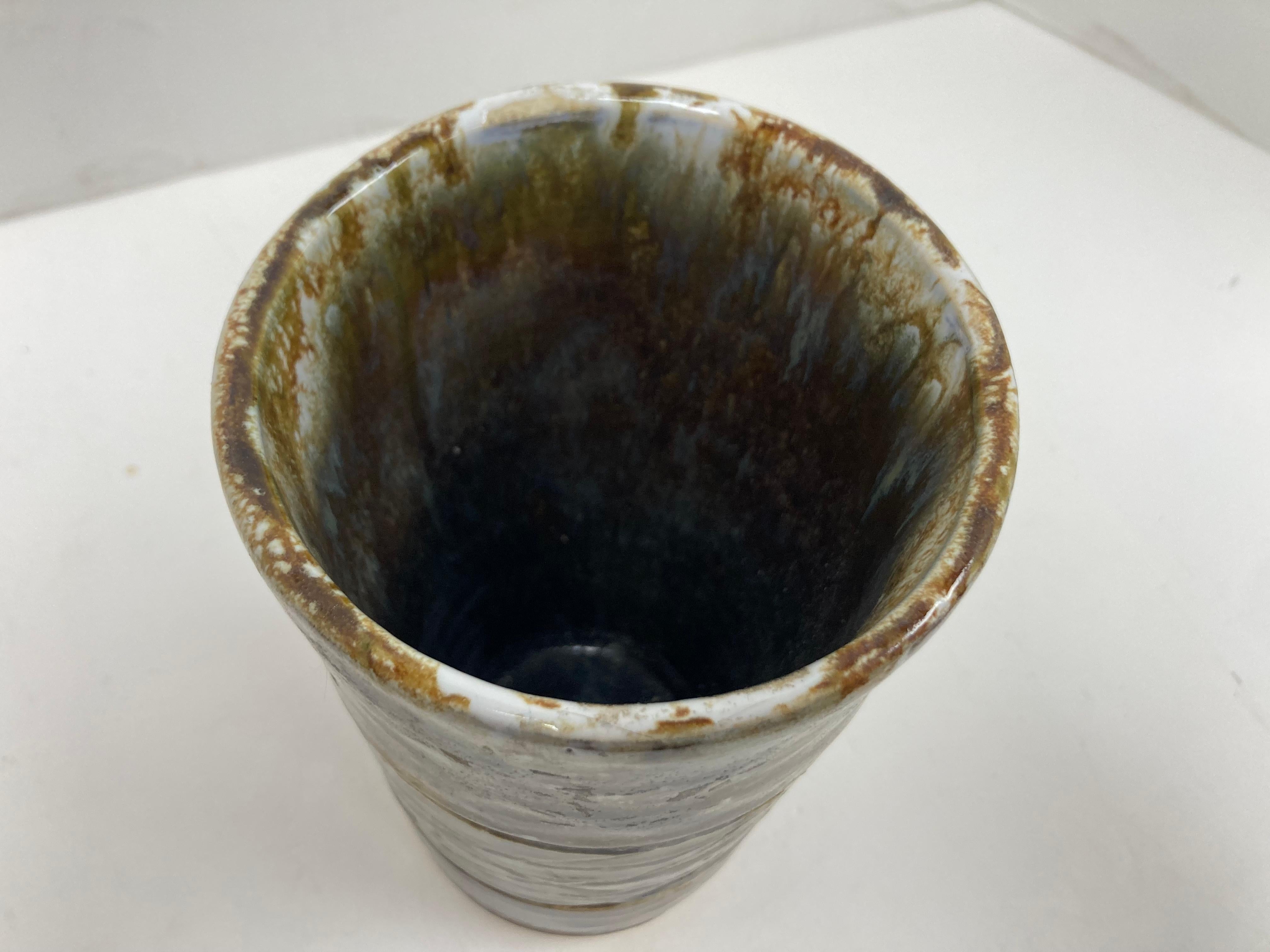 Vaso Studio Pottery di buona fattura con linee primitive incise in una fascia centrale con motivo a diamante. Con una forte forma di Beaker, il pezzo ha un buon peso e una tavolozza di colori naturali di Oliver e Brown. Senza segno. 

Dimensioni: