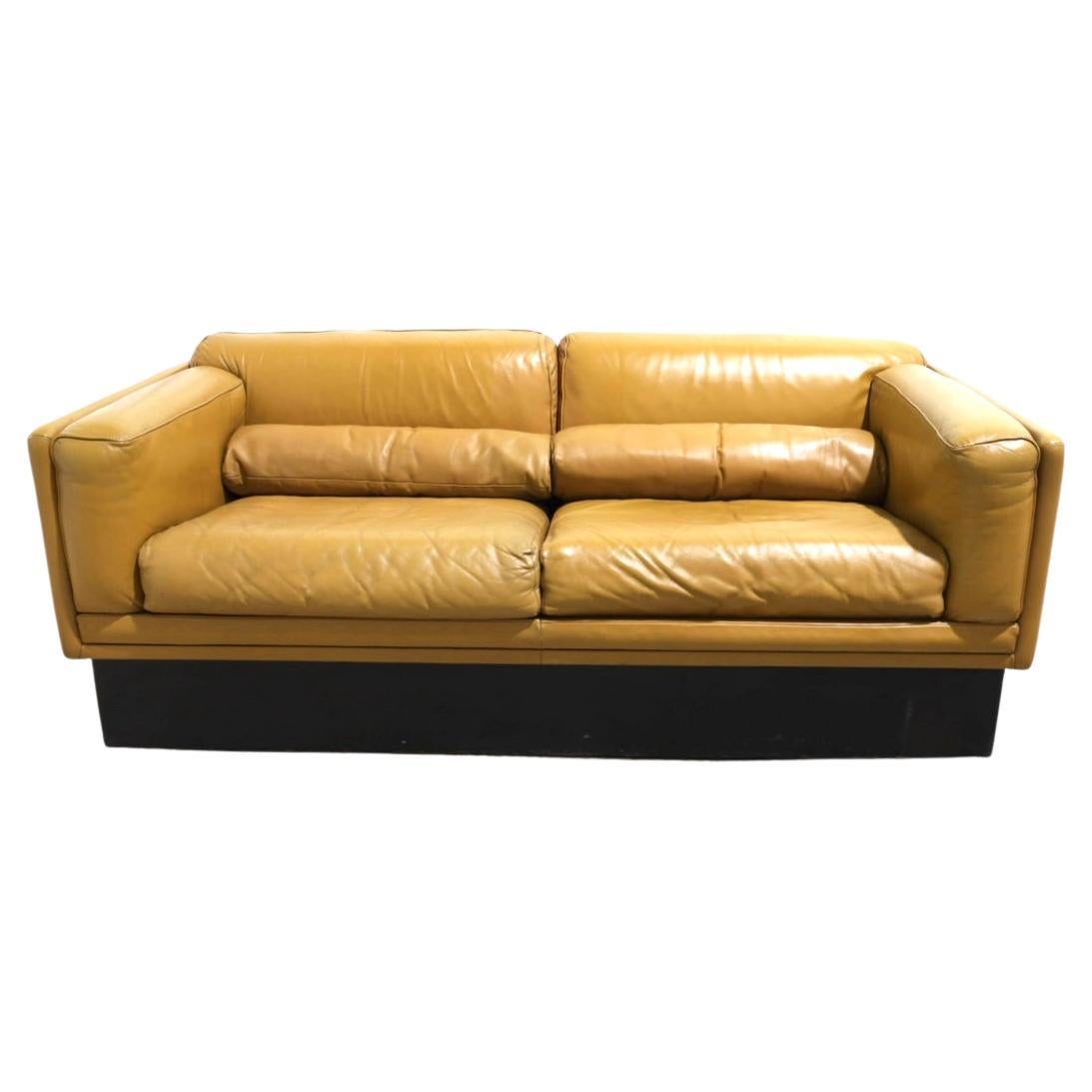 Un precioso sofá Loveseat de cubo bajo de cuero firmado sobre base de zócalo de madera lacada negra. Diseño encantador - Precioso cuero suave de gran color. Diseñado por Georges van Rijck para Beaufort - Fabricado en Bélgica. Situado en Brooklyn