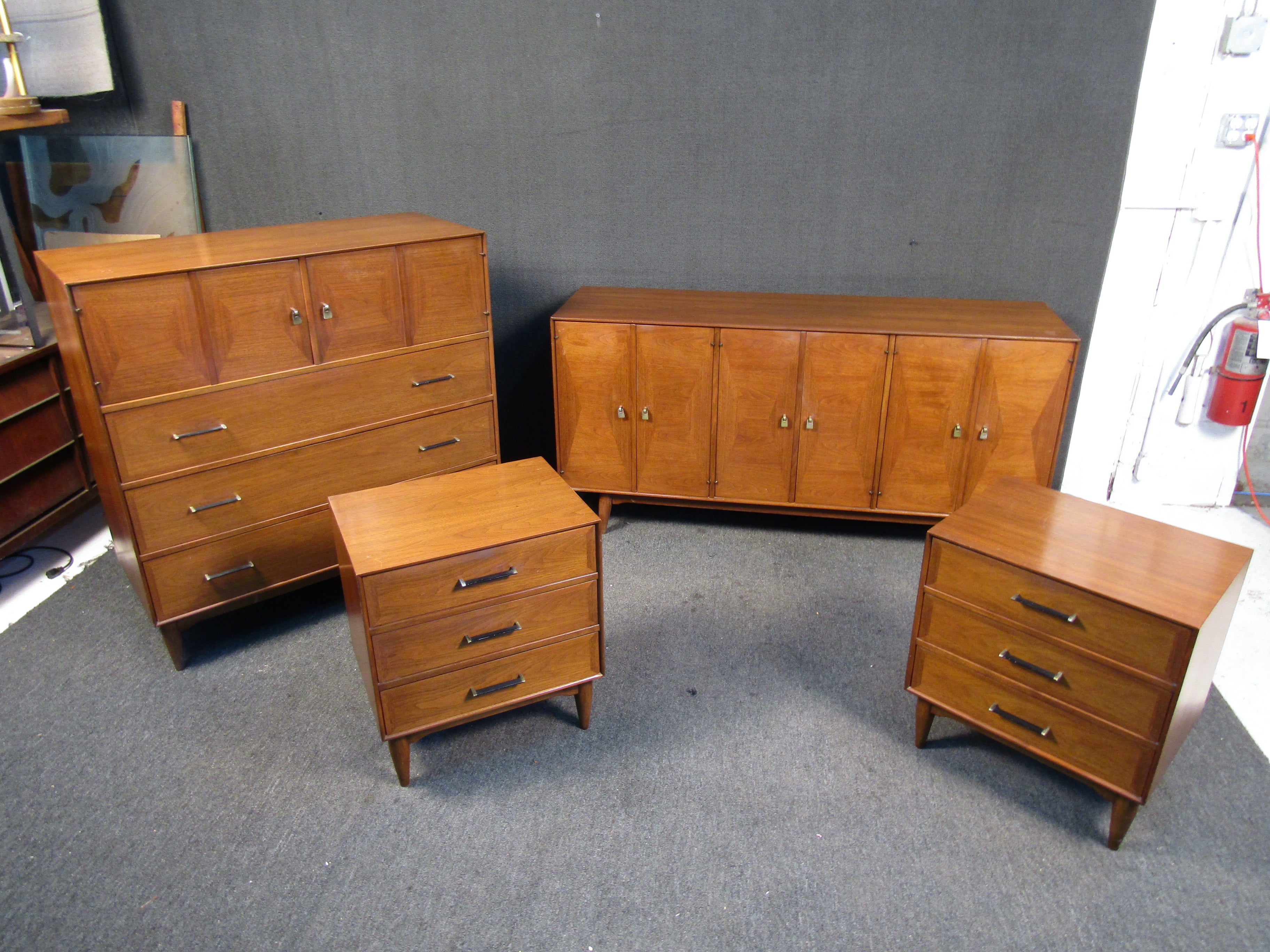 This vintage walnut bedroom set by Ramseur comes fitted with sleek brass finish handles and matching cylindrical walnut legs. The credenza being the largest in terms of storage features nine drawers. 
Please confirm item location (NJ or