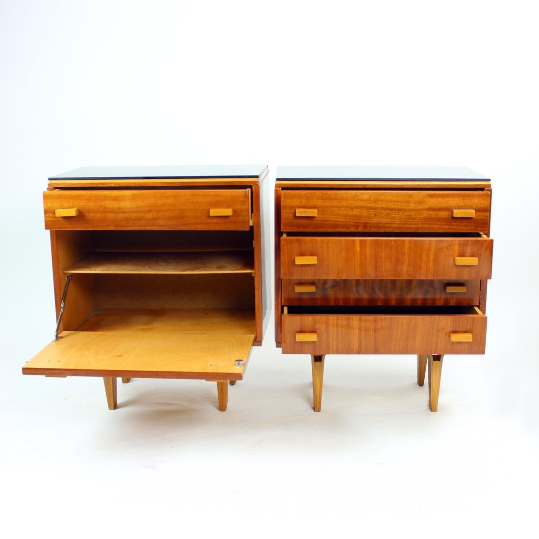 Set of two amazing and elegant bedside tables. Produced in Czechoslovakia by Novy domov in 1960s. Each table stands on legs made of bent plywood and is finished with a plate of black opaline glass on the top. The glass is in a very good condition,