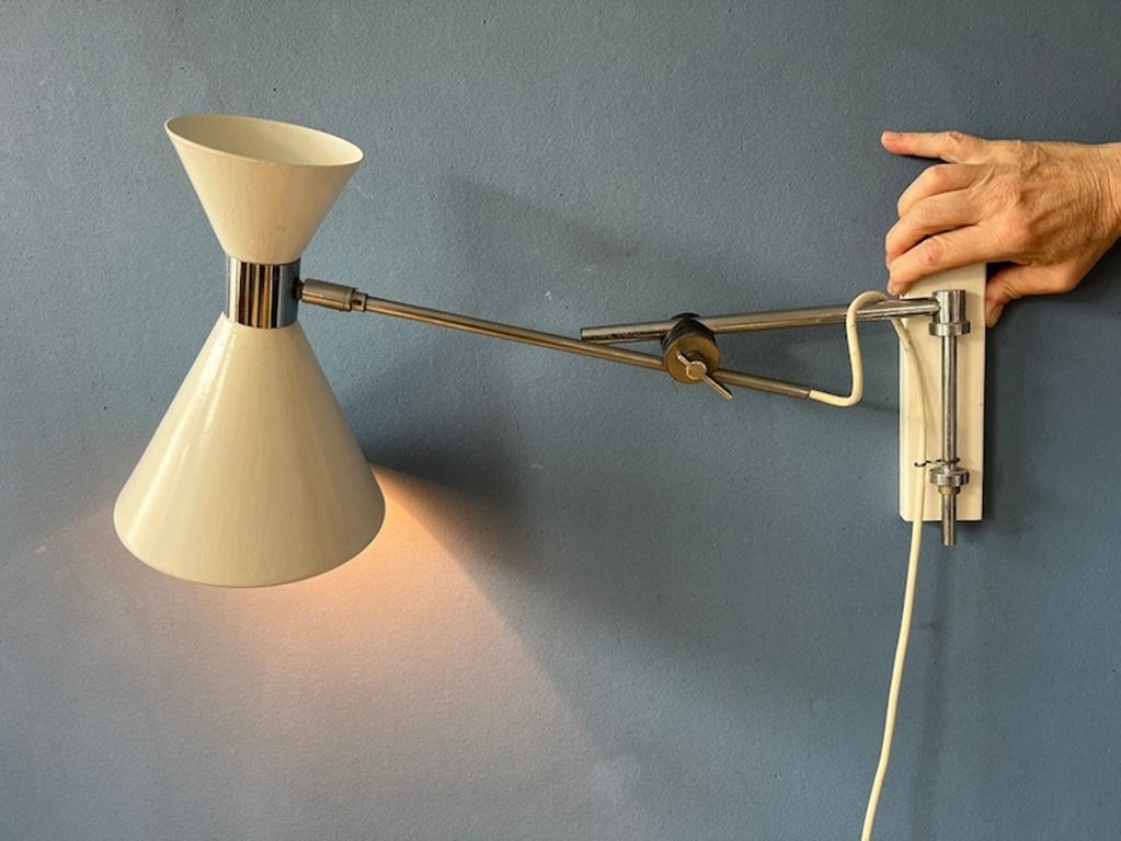 Often sought after Herda diabolo swing arm wall lamp with beige shade. The shade can be turned in different directions and the arm can be positioned in any way desirable where the arms meet. The lamp can swivel left and right from the wall mount.