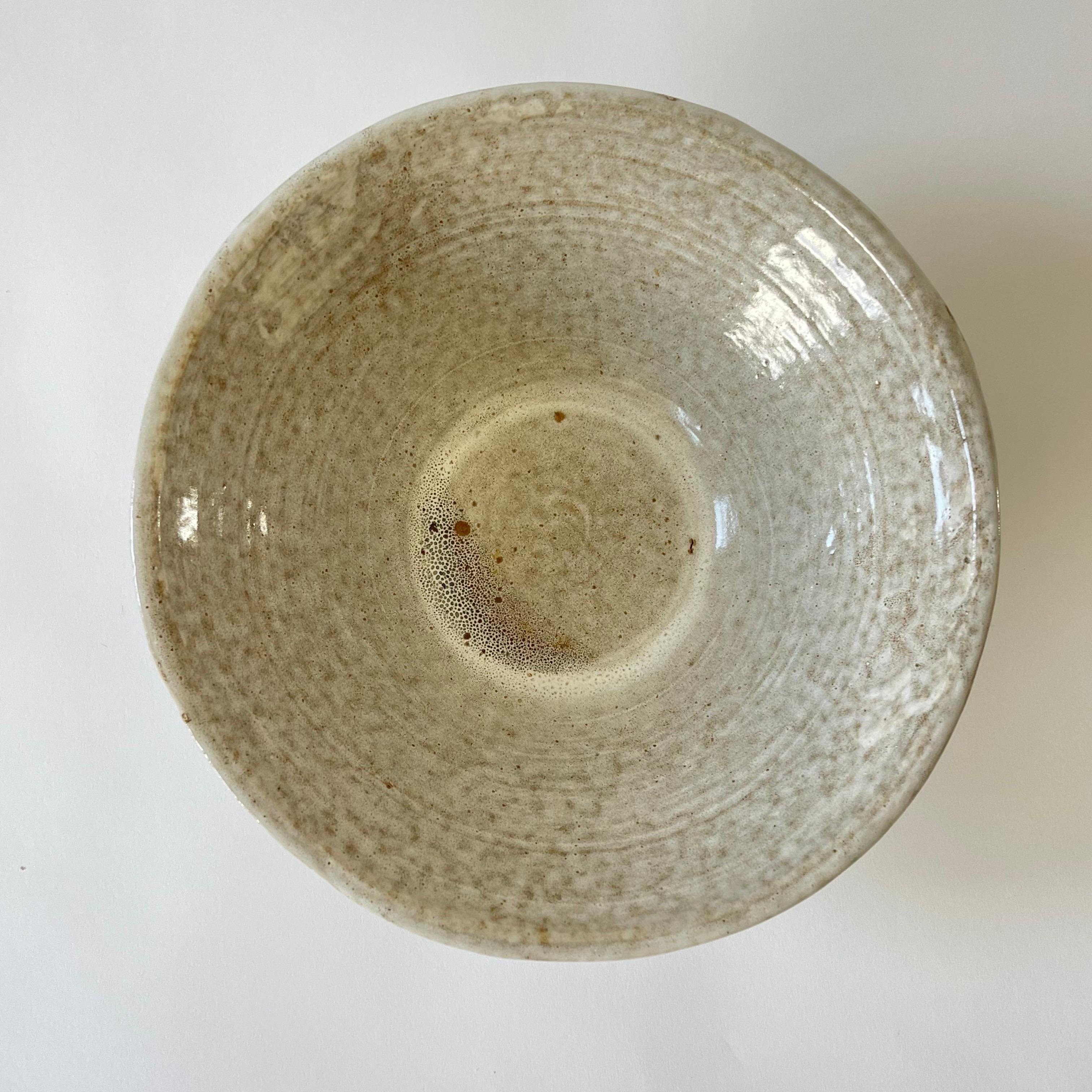 Cuenco de cerámica orgánica moderna de mediados del siglo XX, esmaltado en beige y marrón, con almohadillas de fieltro en la base.  Perfecto como frutero, centro de mesa o cuenco o recipiente decorativo.  EE.UU., década de 1960.
