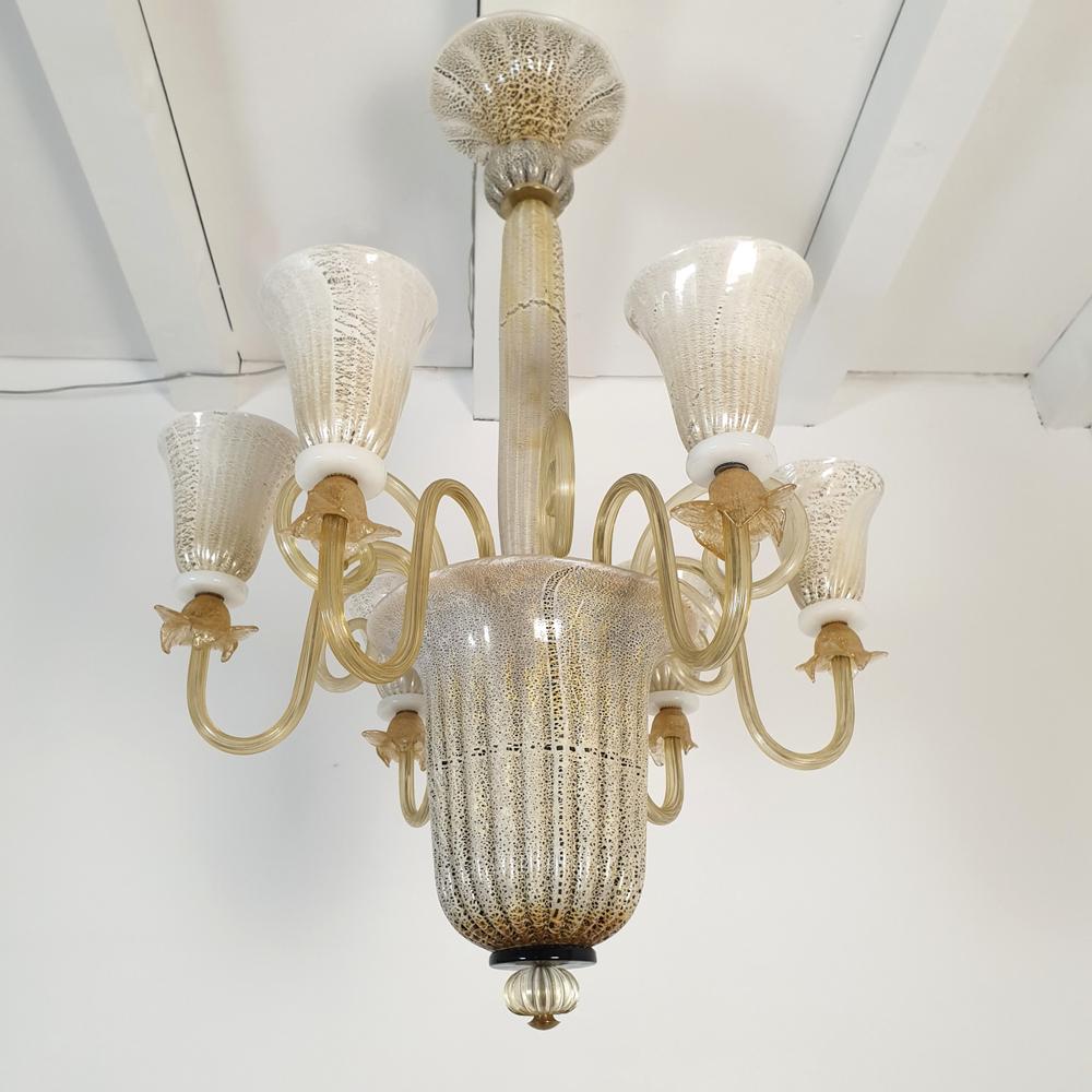 Tall Mid-Century Murano glass chandelier, attributed to Venini, Italy 1960s.
The chandelier is made of a white and brown spotted Murano glass, with gold leaf ornements.
The neoclassical style Murano chandelier has 6 arms and lights.
The Murano glass