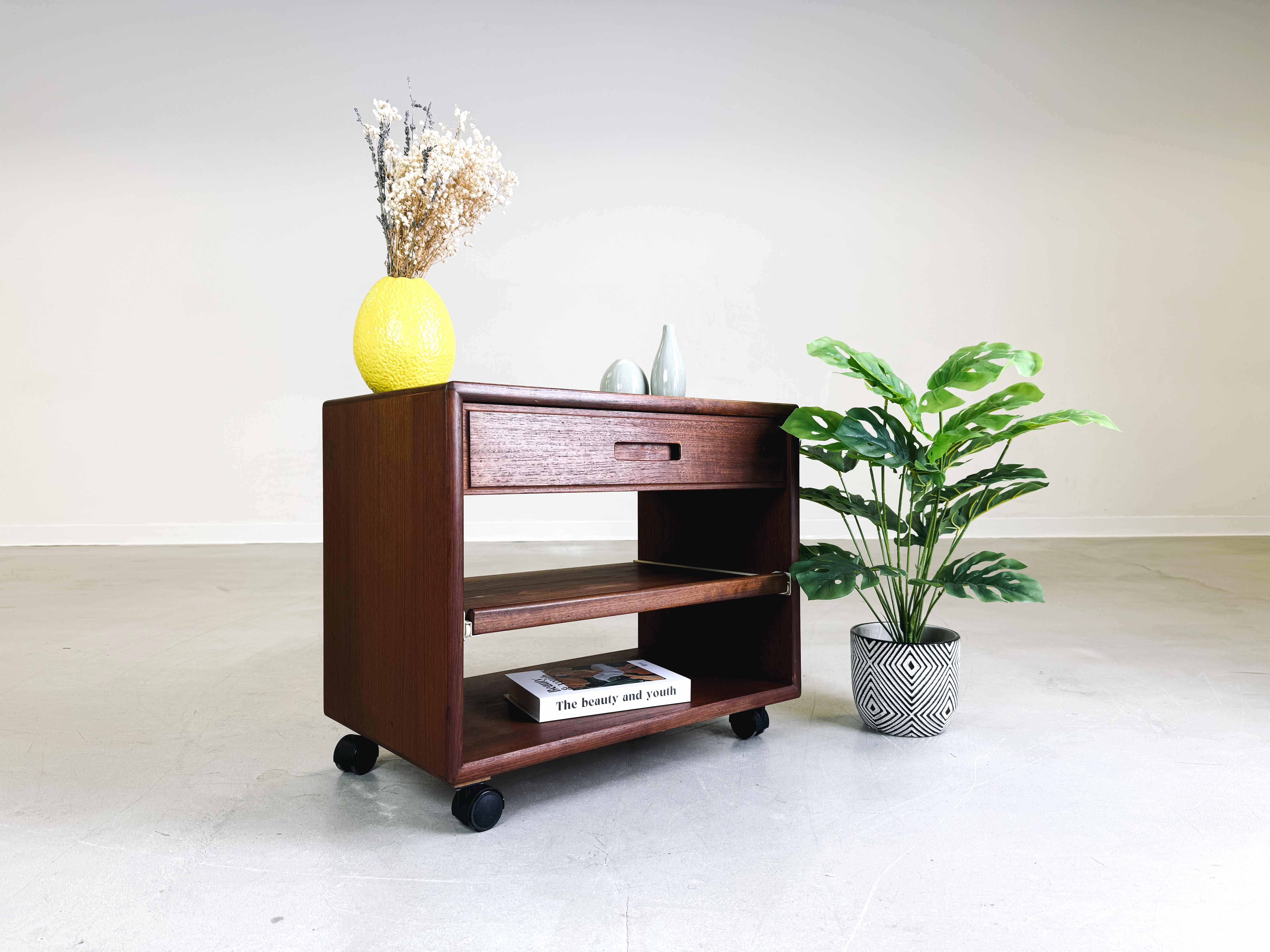 We are offering a beautiful midcentury teak side table from the 1960s for sale. The table was designed as a telephone table, but today it can also be used very well as a coffee table or side table. The drawer can be pulled out in one direction, with