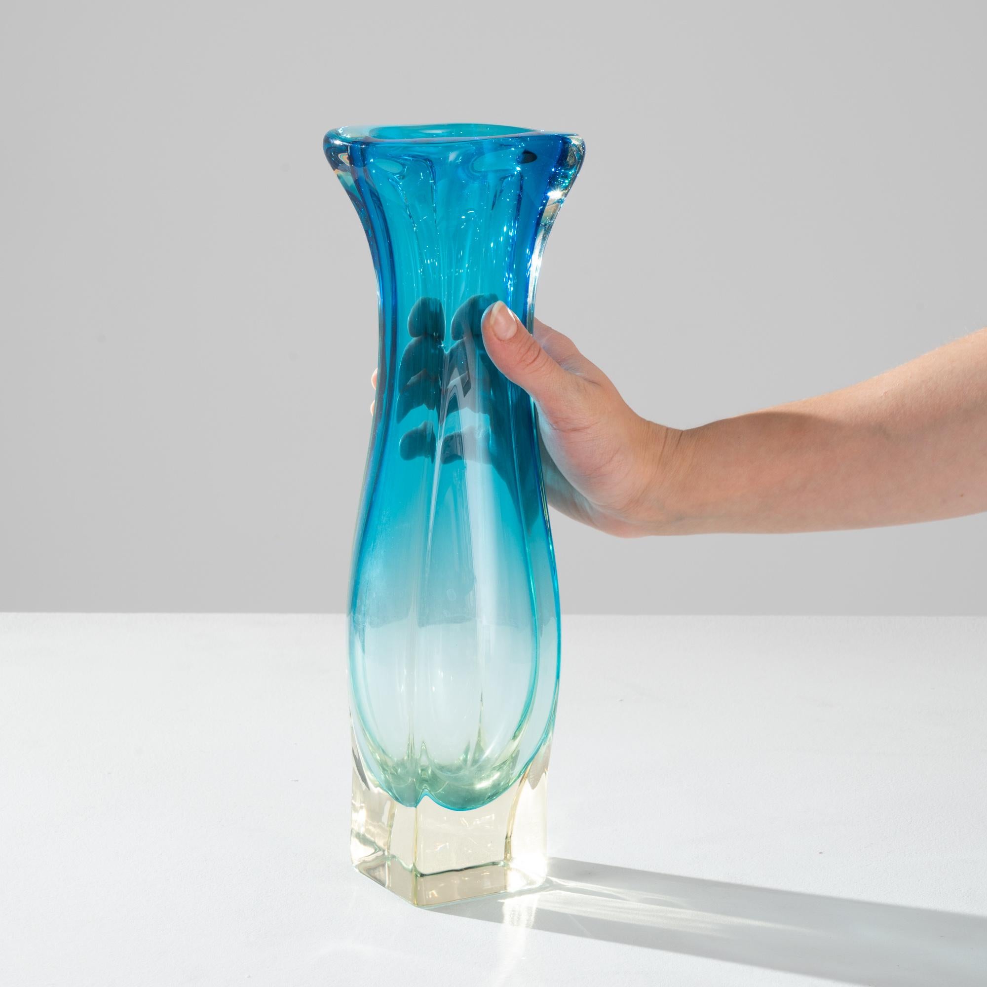 Die lebendigen Farbtöne und flüssigen Linien des geblasenen Kunstglases setzen einen unübersehbaren Akzent. Um 1960 in Belgien hergestellt, formt die ausdrucksstarke Glasarbeit eine kühne Silhouette. Organisch und abstrakt, erinnert es an einen