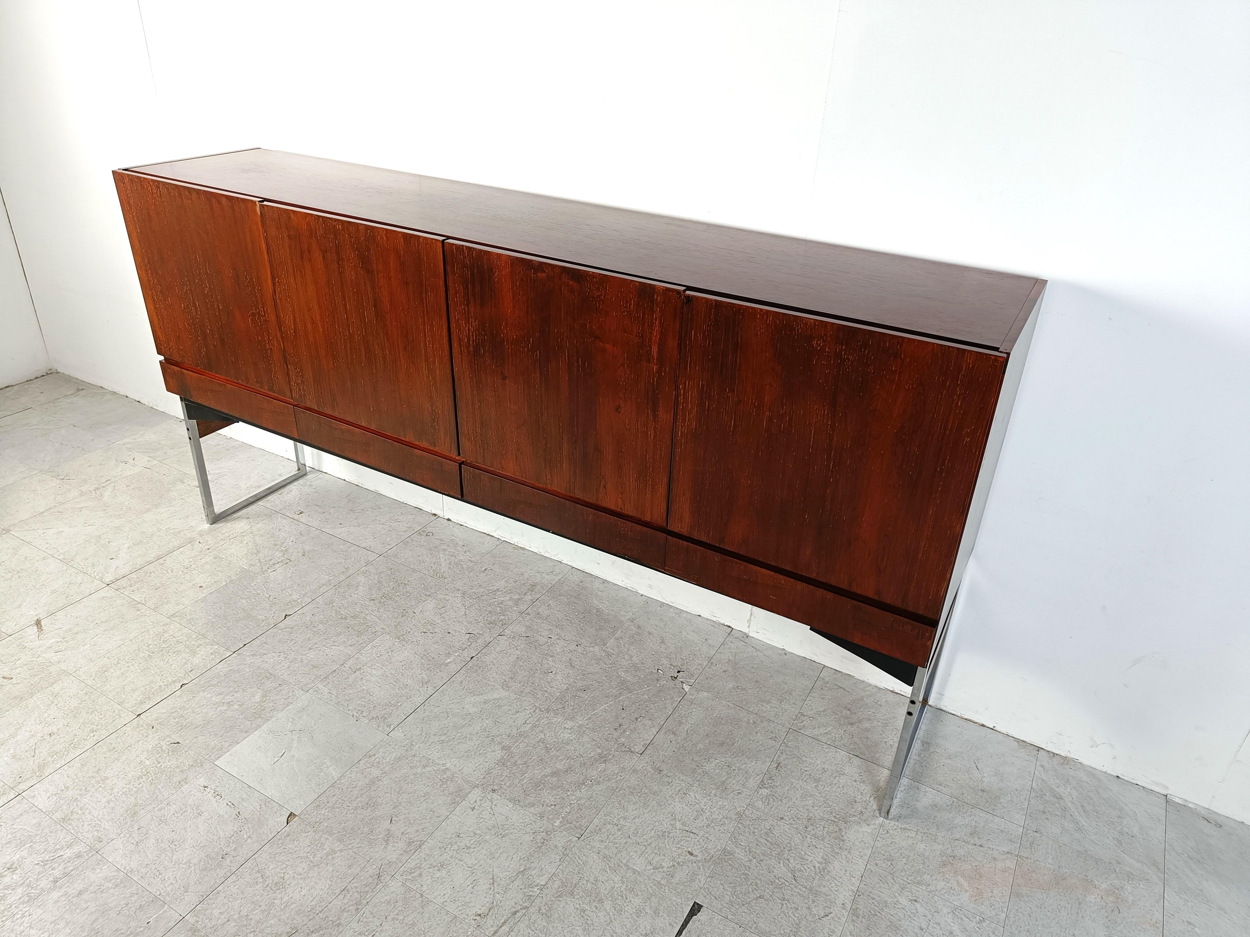 Great looking mid century highboard or sideboard with beautiful veneer wood and a chrome and wooden base.

The sideboard consists of 4 doors and 4 drawers providing loads of storage space.

Very much in the style of Rudolf Glatzel's design, this