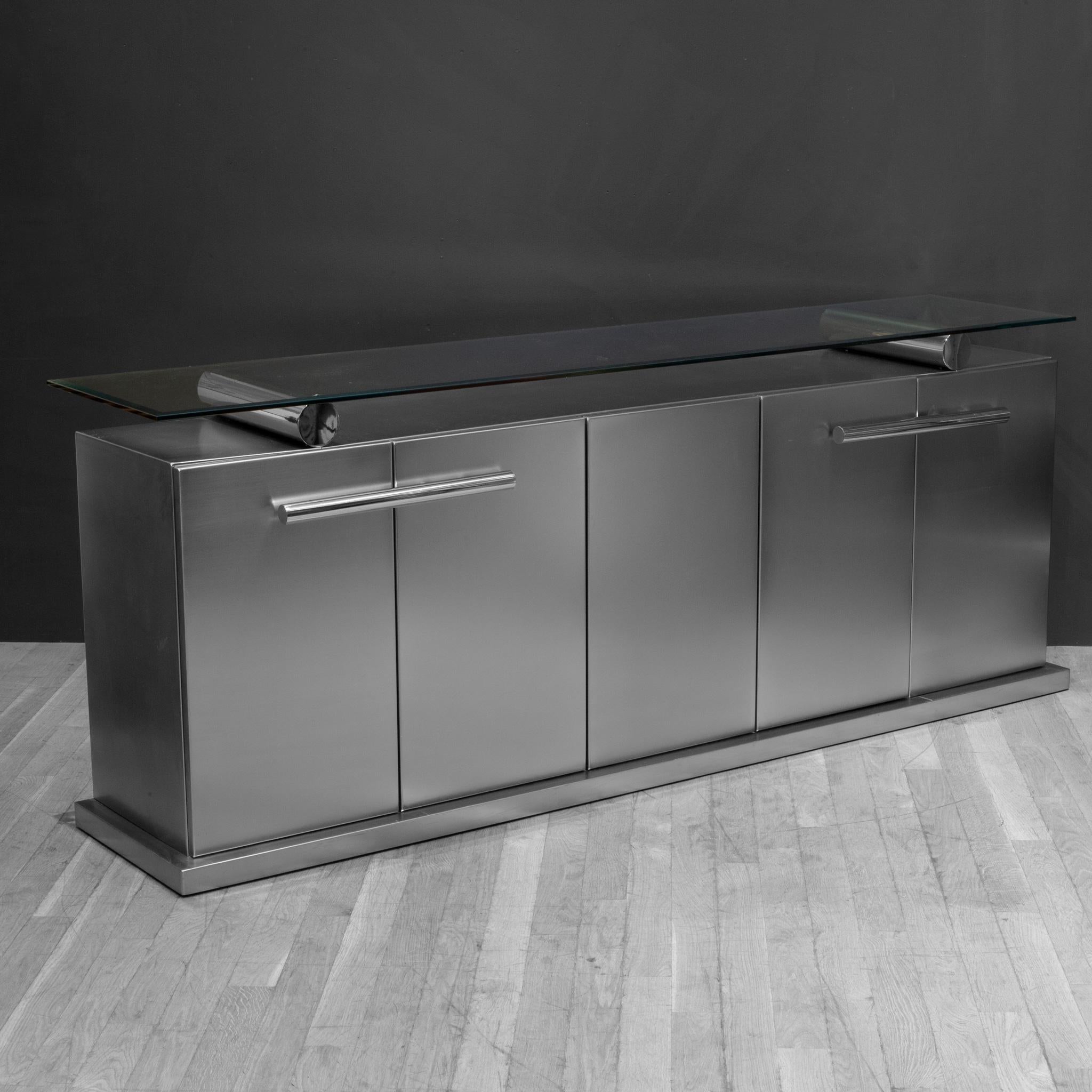 ABOUT

For more affordable shipping options, please contact S16 Home San Francisco. 

Belgo Chrome sideboard in brushed stainless steel with round chrome handles and round glass supports and a thick floating glass top.  The five door sideboard has