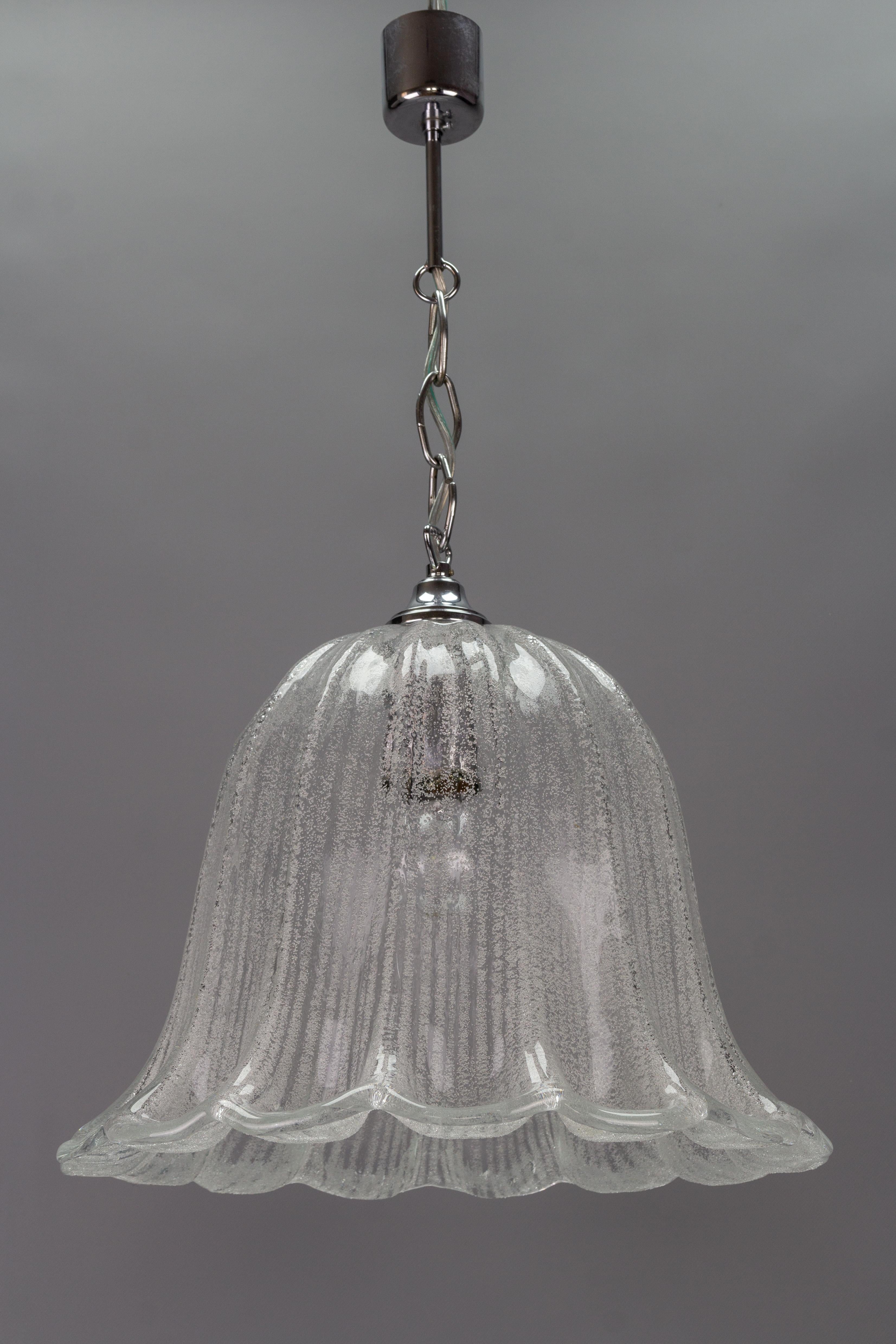 An elegant Mid-Century Modern pendant light fixture with a beautifully shaped ice glass shade and chrome-plated metal fitting. Made in Germany, circa the 1970s by Hustadt - Leuchten.
One socket for E27 (E26) light bulb.
Dimensions: height: 70 cm /