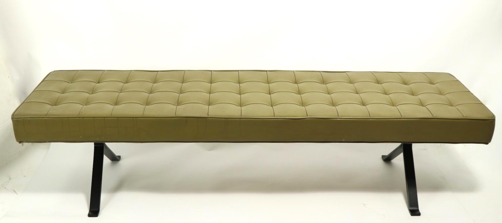 Stylish Mid Century bench having an upholstered top on inverted Y shaped metal legs. The top is of green vinyl, which shows some cosmetic wear, the legs are heavy solid metal, newly powder coated in semi gloss black. In the style of Milo Baughman,