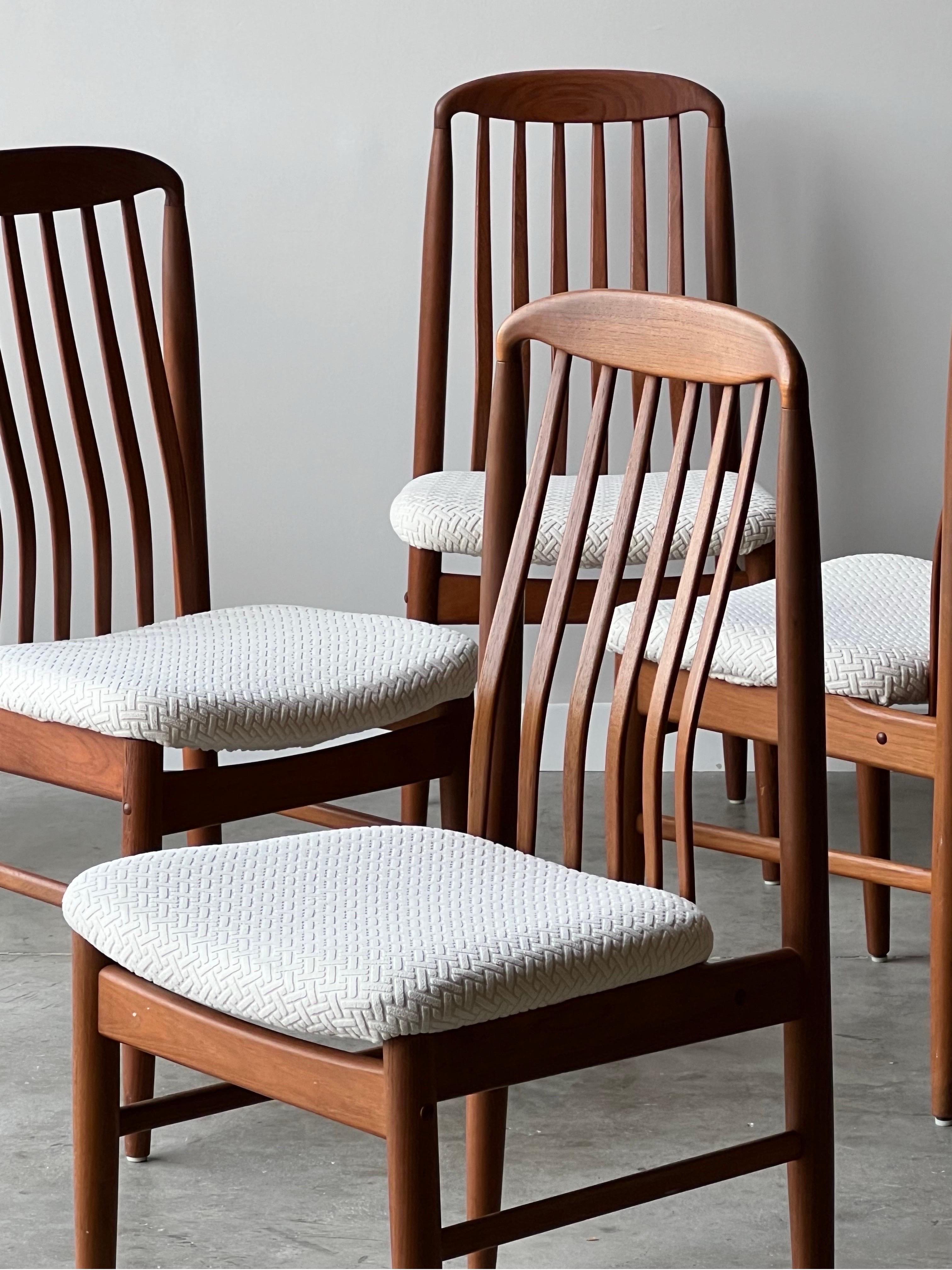 Mid-century set of six dining chairs designed by Benny Linden, Denmark. Made from Danish teak wood. The legs of the chairs are sculpted tapered teak. The back legs lead all the way to the top of the chair. The backrest consists of teak slats that