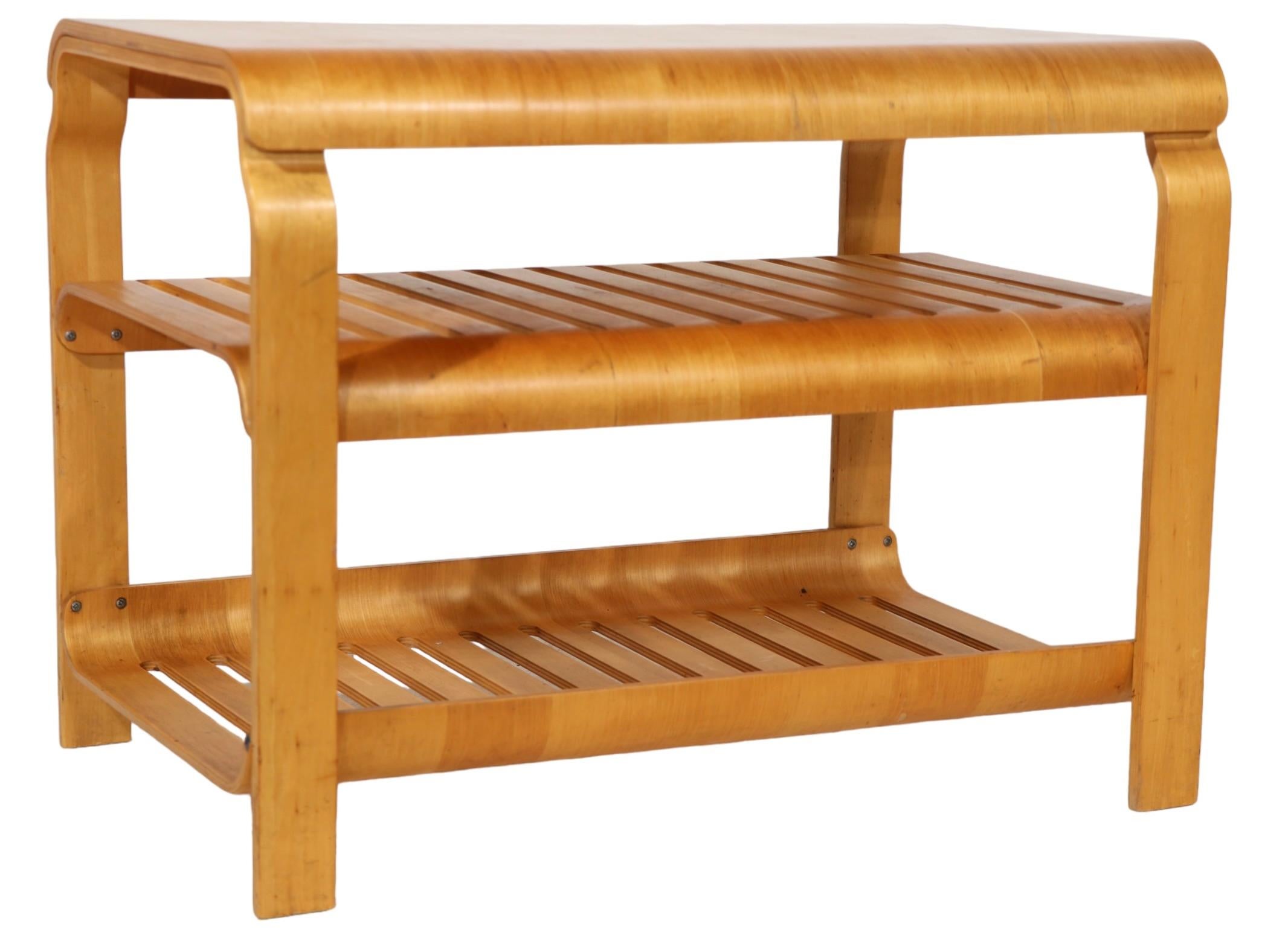 Bentwood three tier table made by Ikea, in the style of Alvar Aalto. The table features formed plywood shelves, which can be adjusted in height and faced curved edge up, or down. This is an early example of the influential and important production