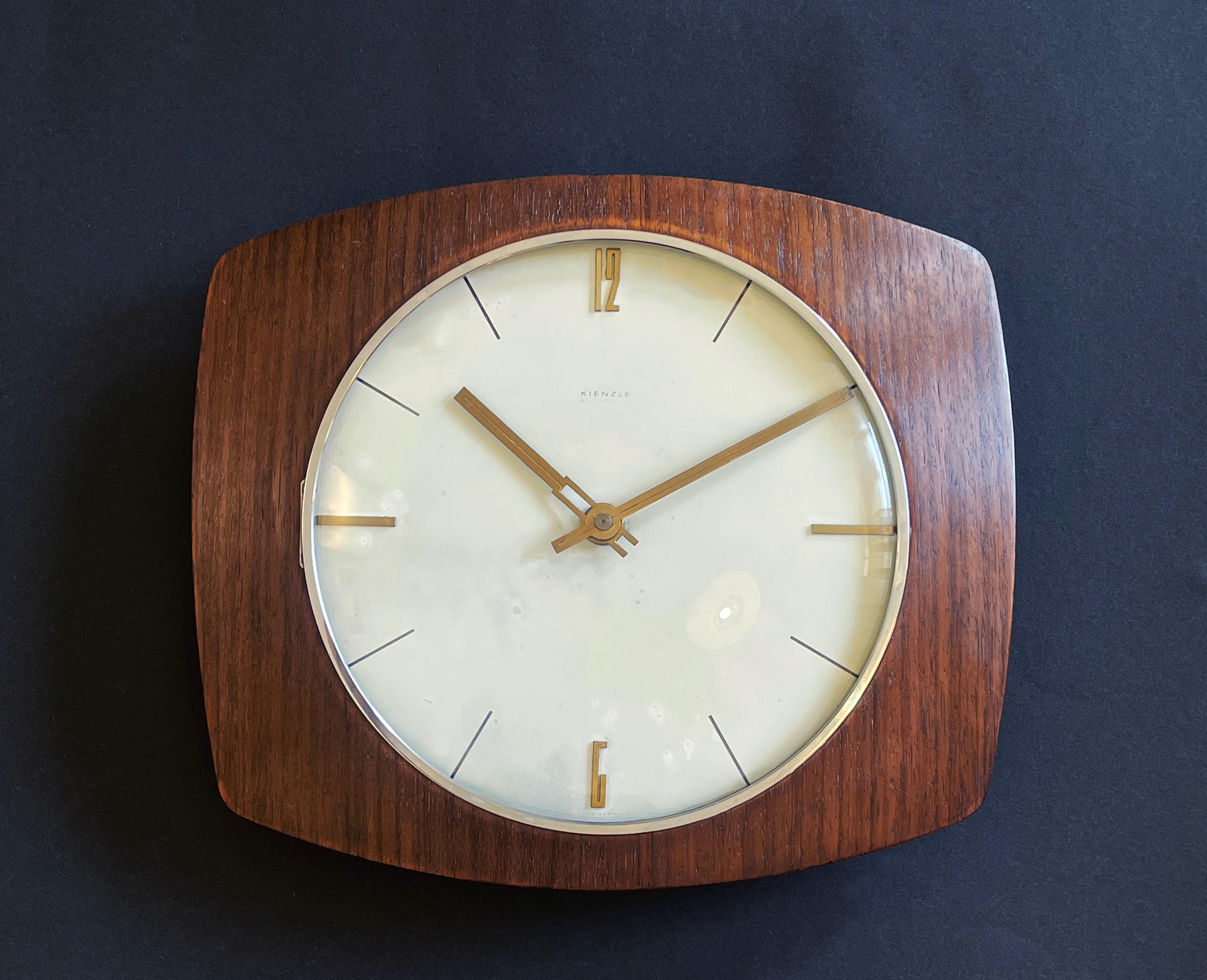 Bellissimo orologio da parete di Kienzle in multistrato di teak curvato, con un design anni '70 di uno dei più famosi designer tedeschi. 
rinomati orologiai di metà e fine secolo.
Realizzato alla fine degli anni '60 e all'inizio degli anni '70.
Qui
