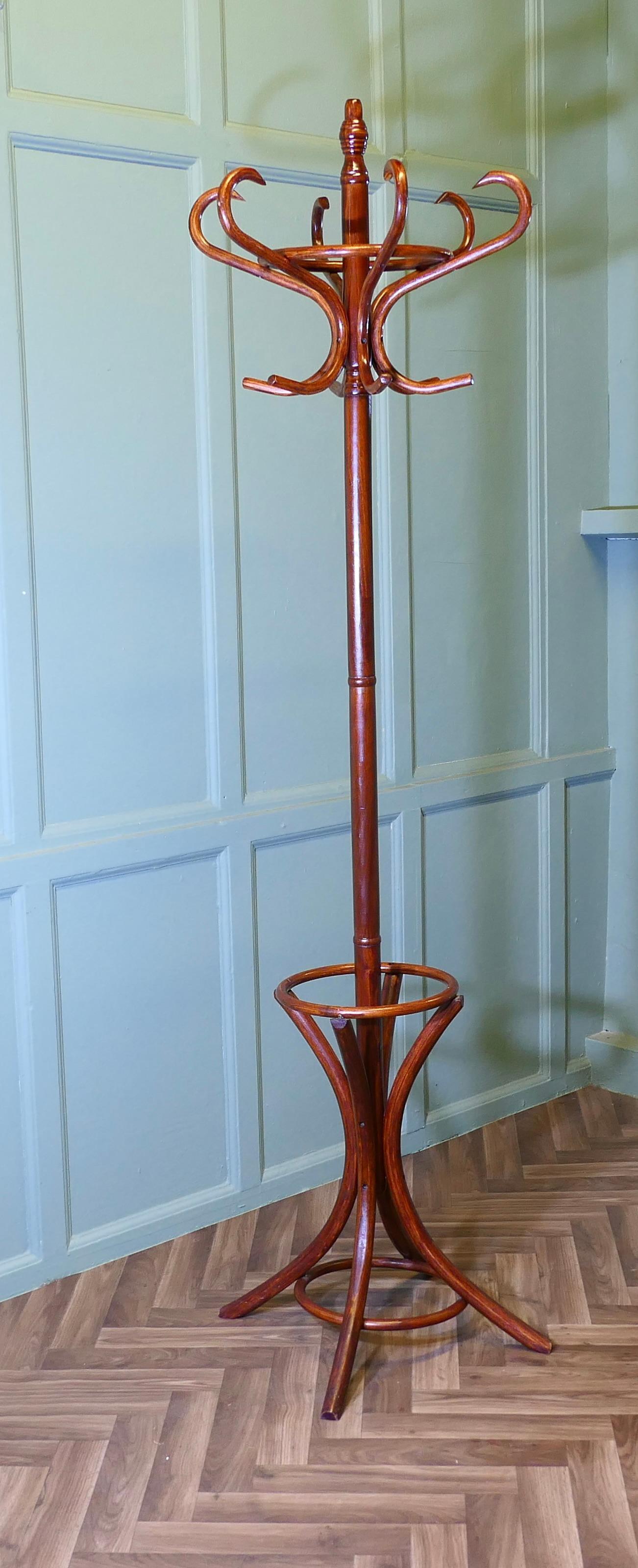 Appendiabiti e cappelliere in legno curvato di metà secolo

Si tratta di un'appendiabiti rotondo, con 6 grandi ganci in legno curvato per cappelli e cappotti nella parte superiore e 4 gambe strombate che formano il contenitore per gli ombrelli nella