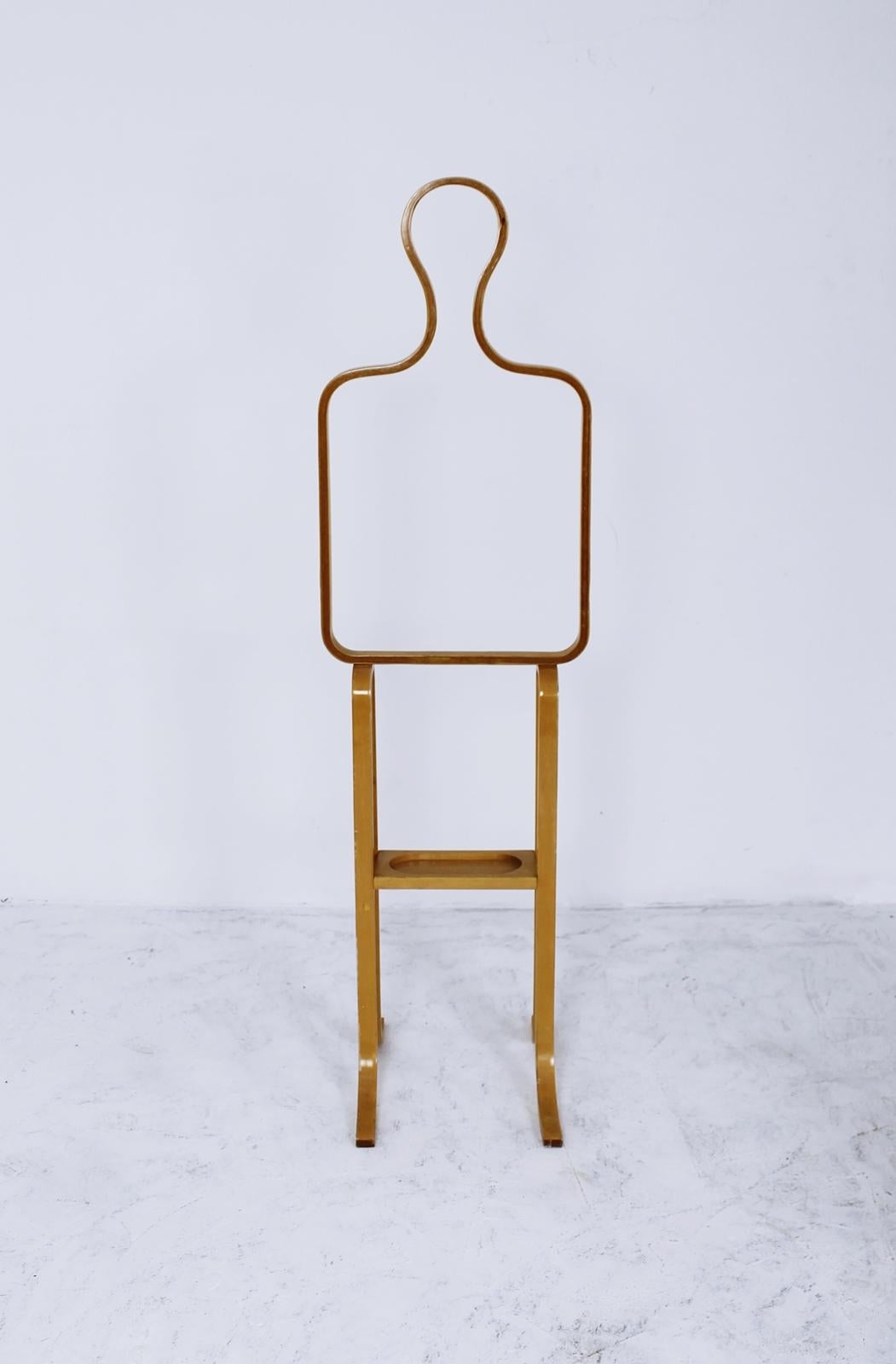 A figurative bentwood valet or coat stand in silhouette form with a small shelf.

The item is in very good condition.

Approximate dimensions:

Measures: Width 42cm
Depth 44cm
Height 150cm.