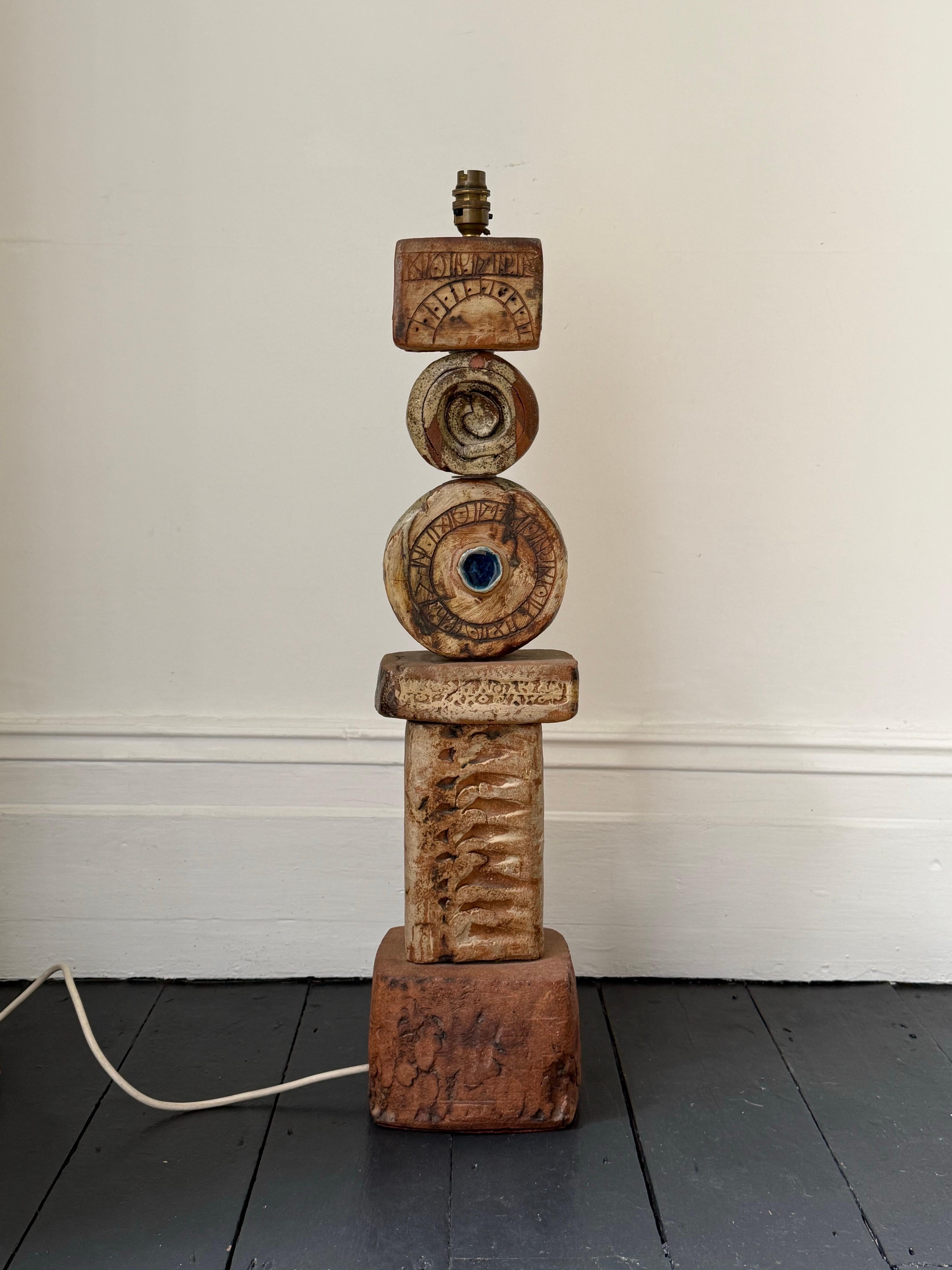 Lámpara TOTEM de cerámica pesada de Bernard Rooke, Inglaterra. Mediados del siglo XX, Inglaterra.

El tótem es una pieza escultórica -de suelo o de mesa- formada por elementos cerámicos en tonos naturales de terracota y piedra. El elemento circular
