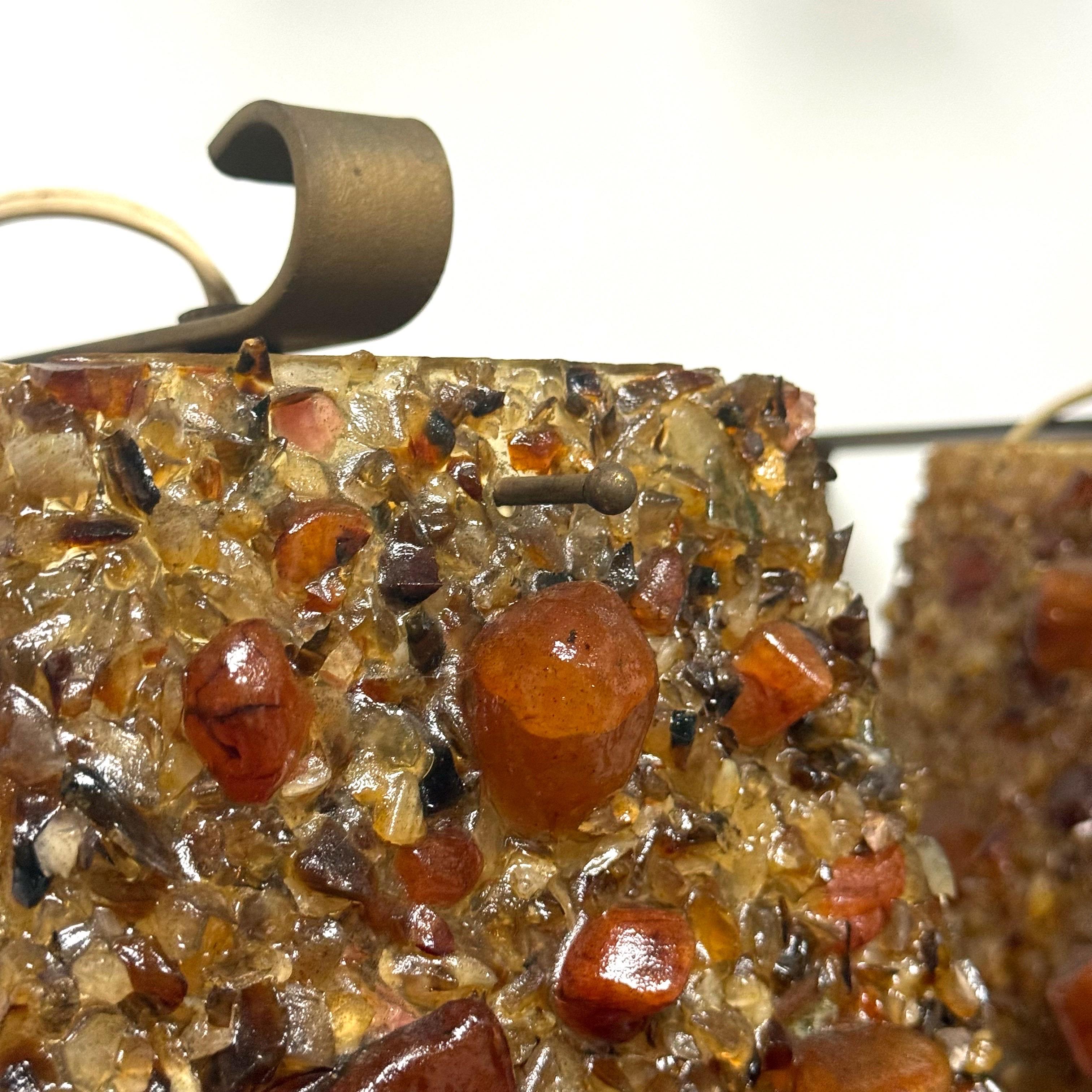 This pair of fantastic mid-20th century brutalist style specimen resin sconces are filled big chunks of polished and unpolished carnelian.  They put off the prettiest glow when lit.  They hang from a lantern style and they are currently wired to
