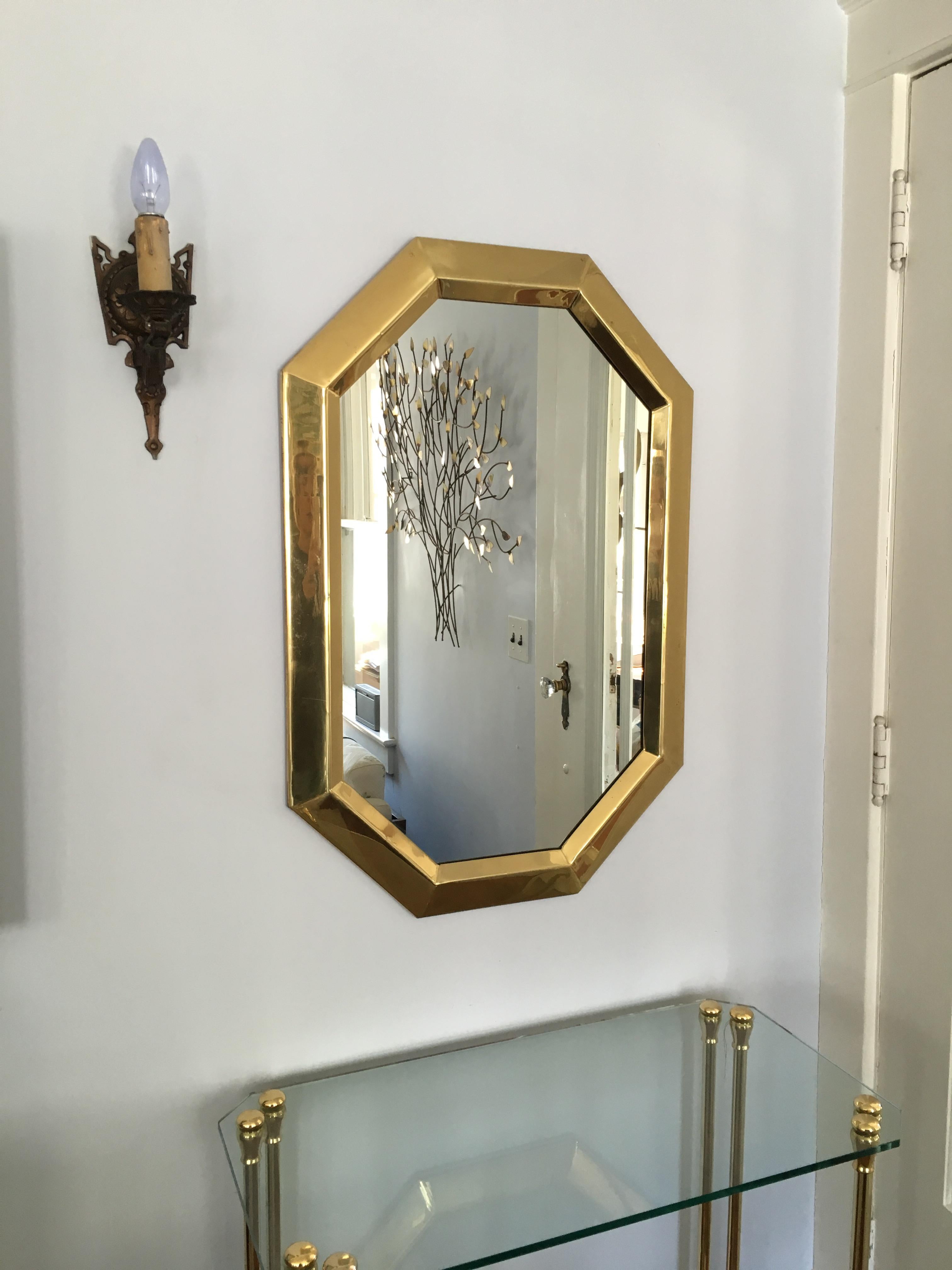 Beautiful classic lines in this brass mirror in the manner of Mastercraft. Mid size mirror enhances any wall in its timeless design. Typical wear.